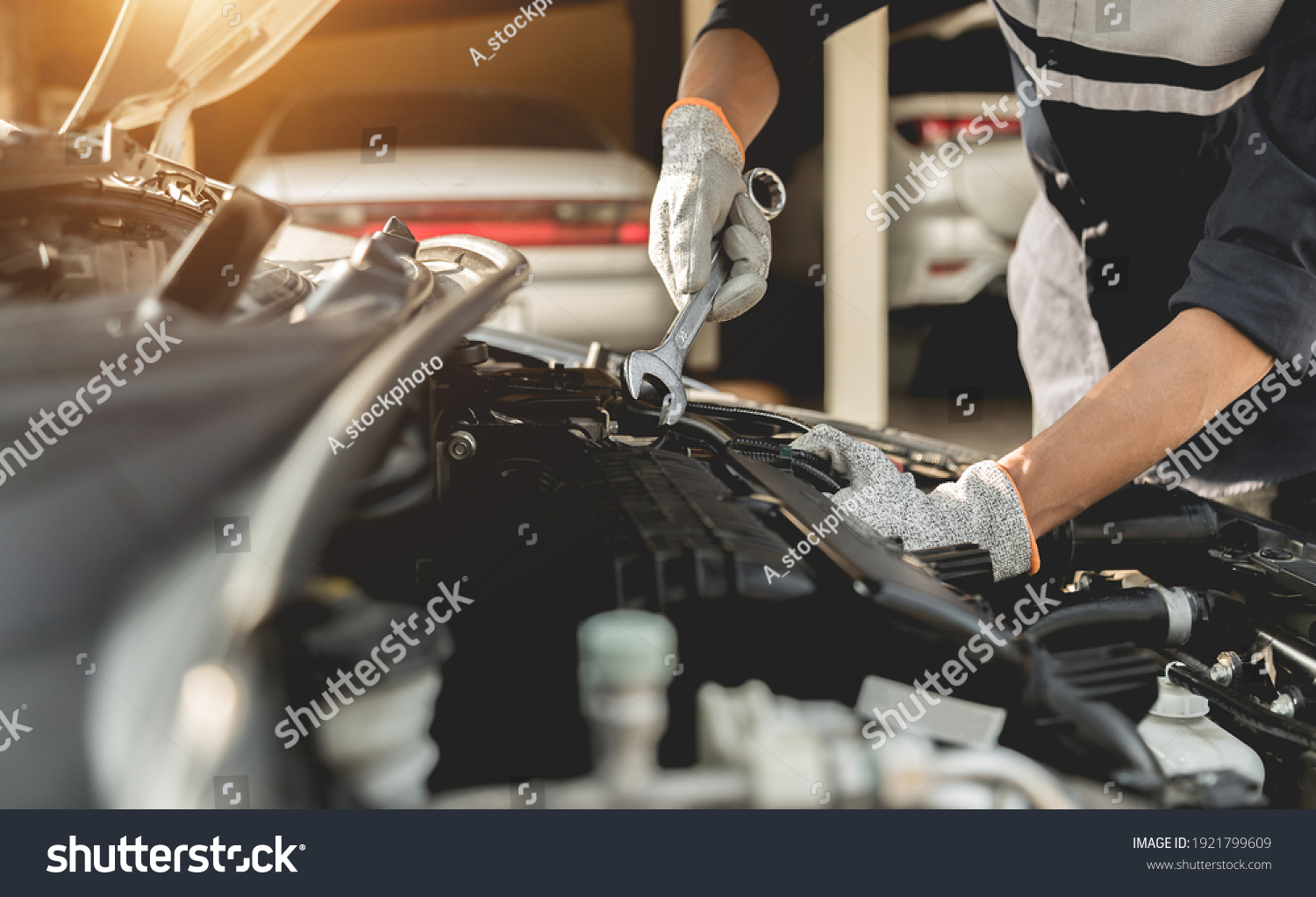 Automobile mechanic repairman hands repairing a car engine automotive workshop with a wrench, car service and maintenance,Repair service. #1921799609