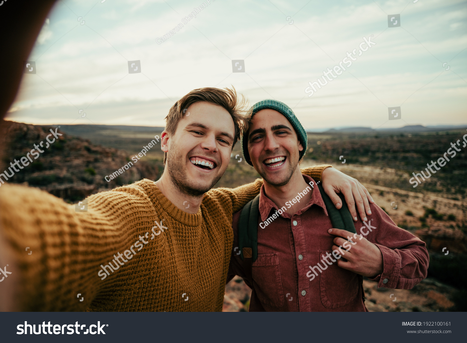 Caucasian male friends hiking in wilderness taking selfie with cellular device embracing the outdoors #1922100161