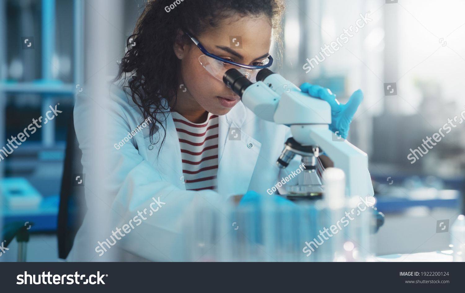 Medical Science Laboratory: Portrait of Beautiful Black Scientist Looking Under Microscope Does Analysis of Test Sample. Ambitious Young Biotechnology Specialist, working with Advanced Equipment #1922200124