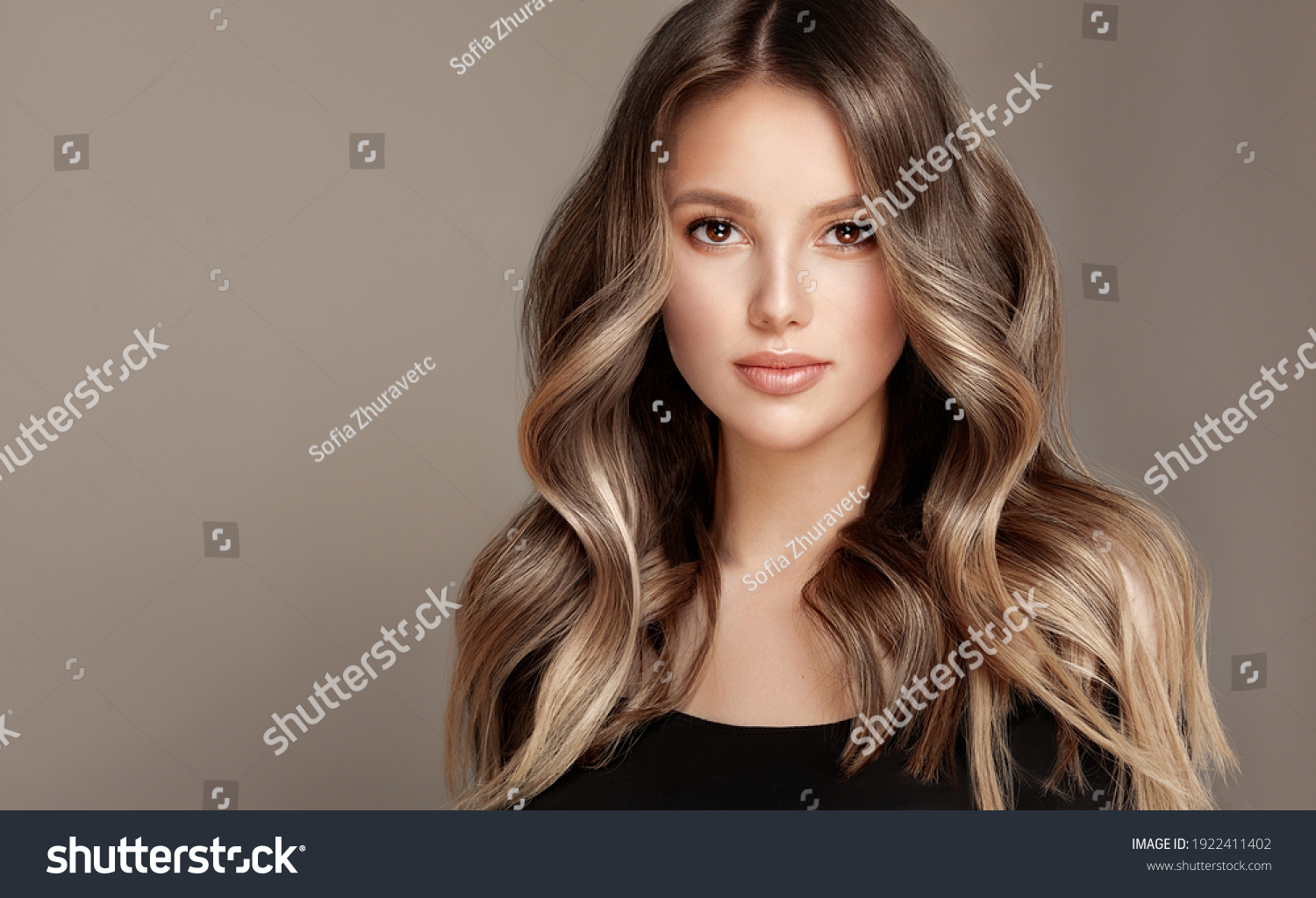 Beauty  girl with long  and   shiny wavy  Hair ,coloring and toning, shatush and balayash .  Beautiful   woman model with curly hairstyle . #1922411402