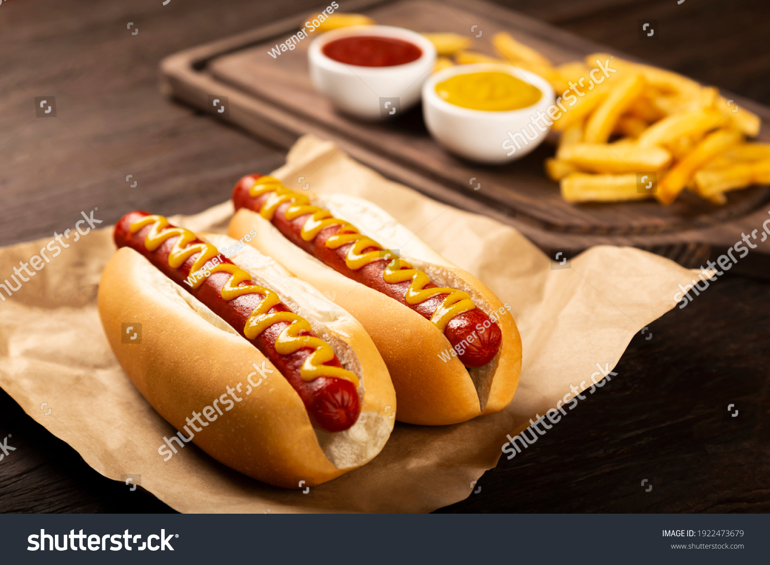 Hot dogs with ketchup, yellow mustard and fries. Image with selective focus #1922473679