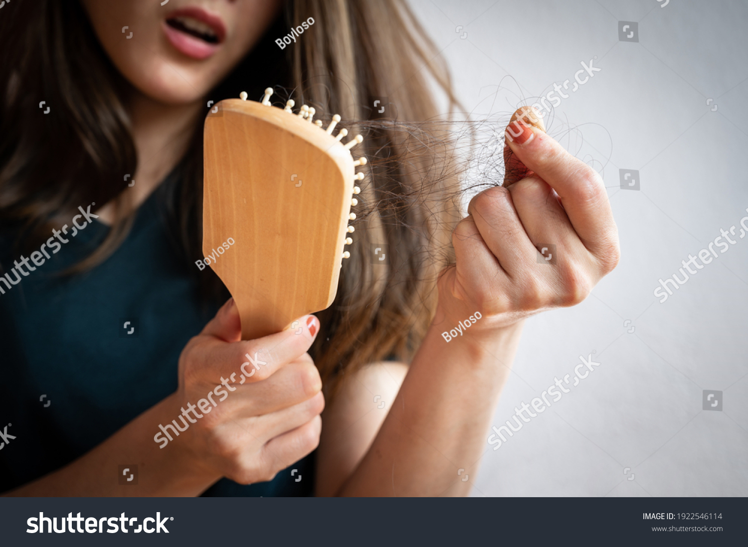 Close-up of worried woman holding comb with hair loss after brushing her hair. Hair loss it cause from family history, hormonal changes, unhealthy of aging. #1922546114