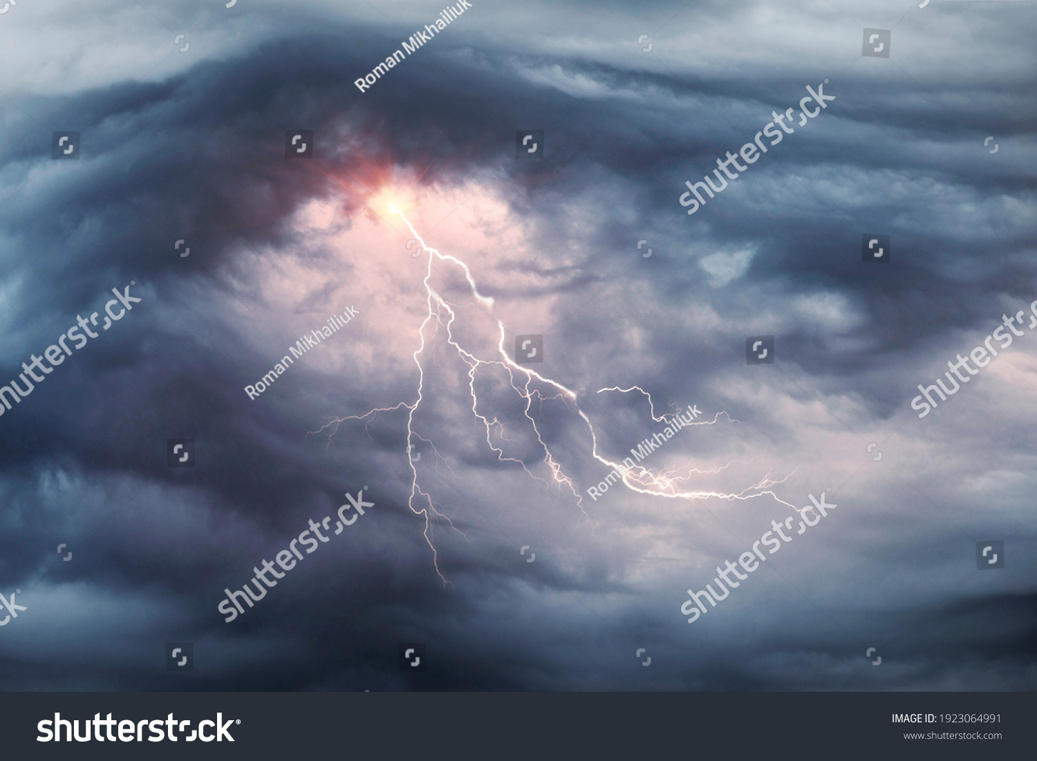 A terrible dangerous storm with a strong wind swirls thunderclouds in the mountains with fabulous twists, from which rain and hail or a thunderstorm with lightning flies. #1923064991