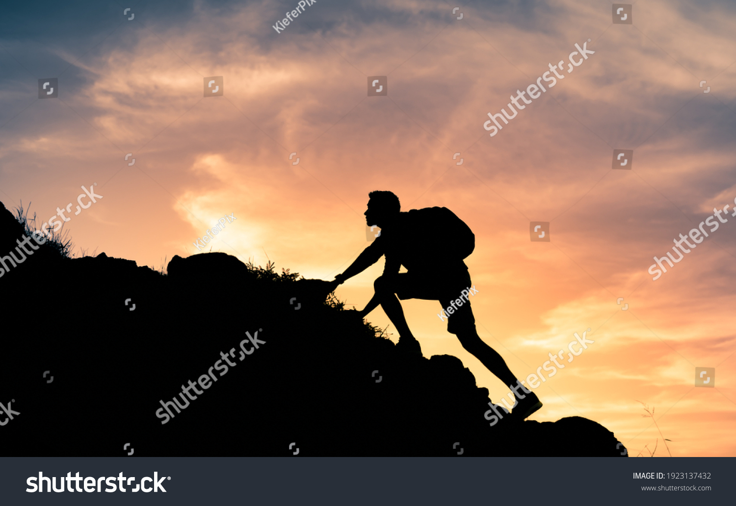 Fit young determined man climbing to top of mountain.  #1923137432