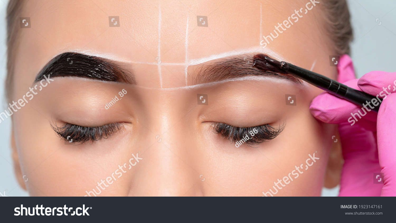 Make-up artist makes markings with white pencil for eyebrow and paints eyebrows. Professional makeup and facial care. #1923147161