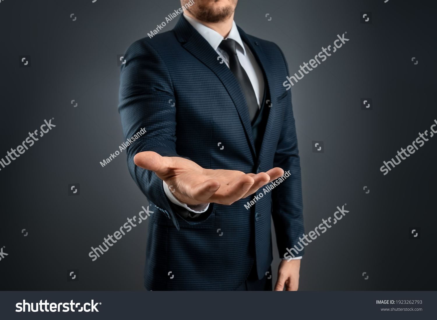 Male hand in a suit shows a palm up gesture on a gray background. Concept of request, bankruptcy, close-up #1923262793