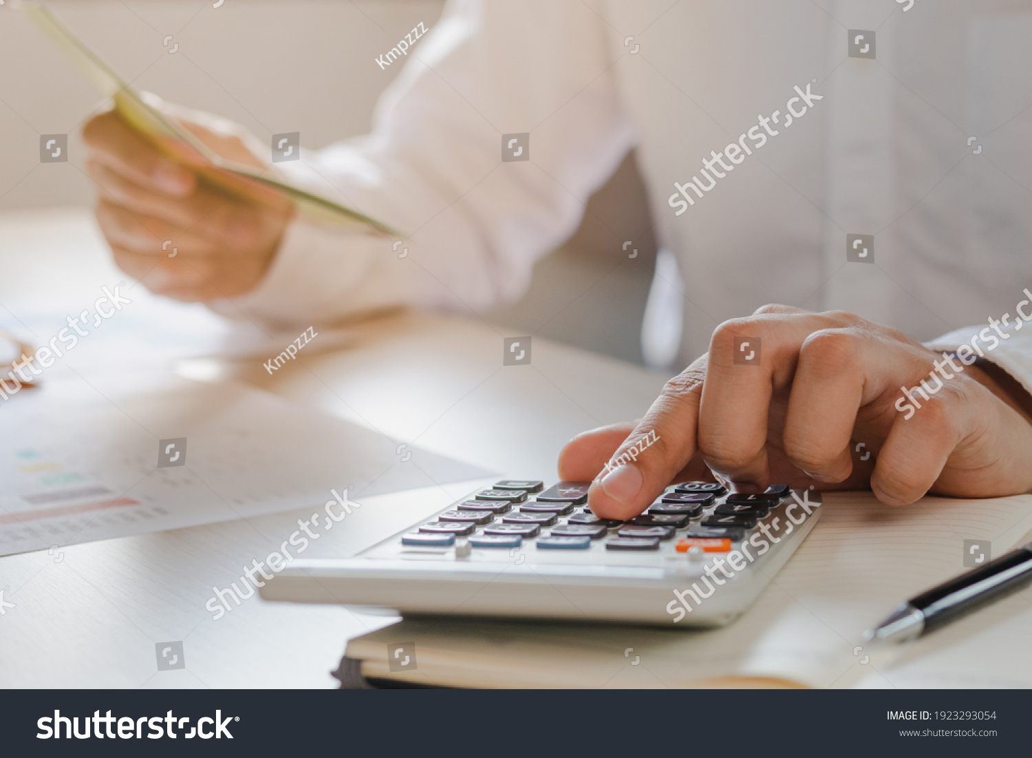 Close up hand of stress young asian businessman,male is pressing a calculator to calculate tax income and expenses, bills, credit card for payment or payday at home, office.Financial, finance concept. #1923293054