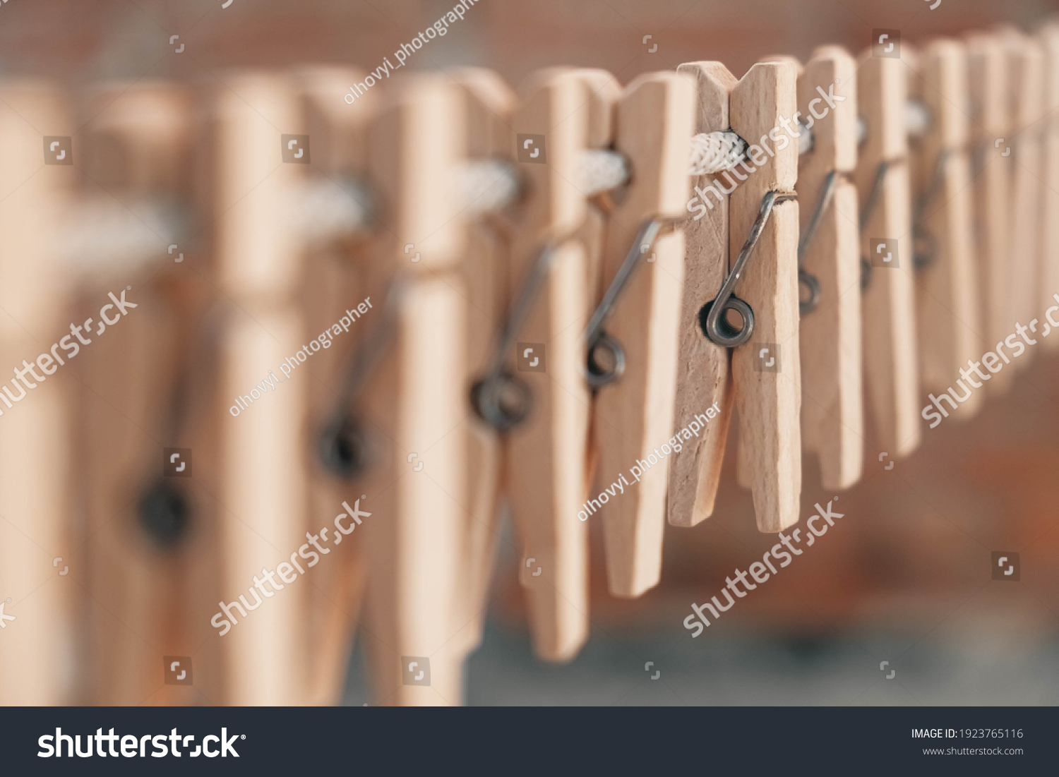 Wooden clothespins on a rope. Selective focus on one clothespin. Copy, empty space for text. #1923765116
