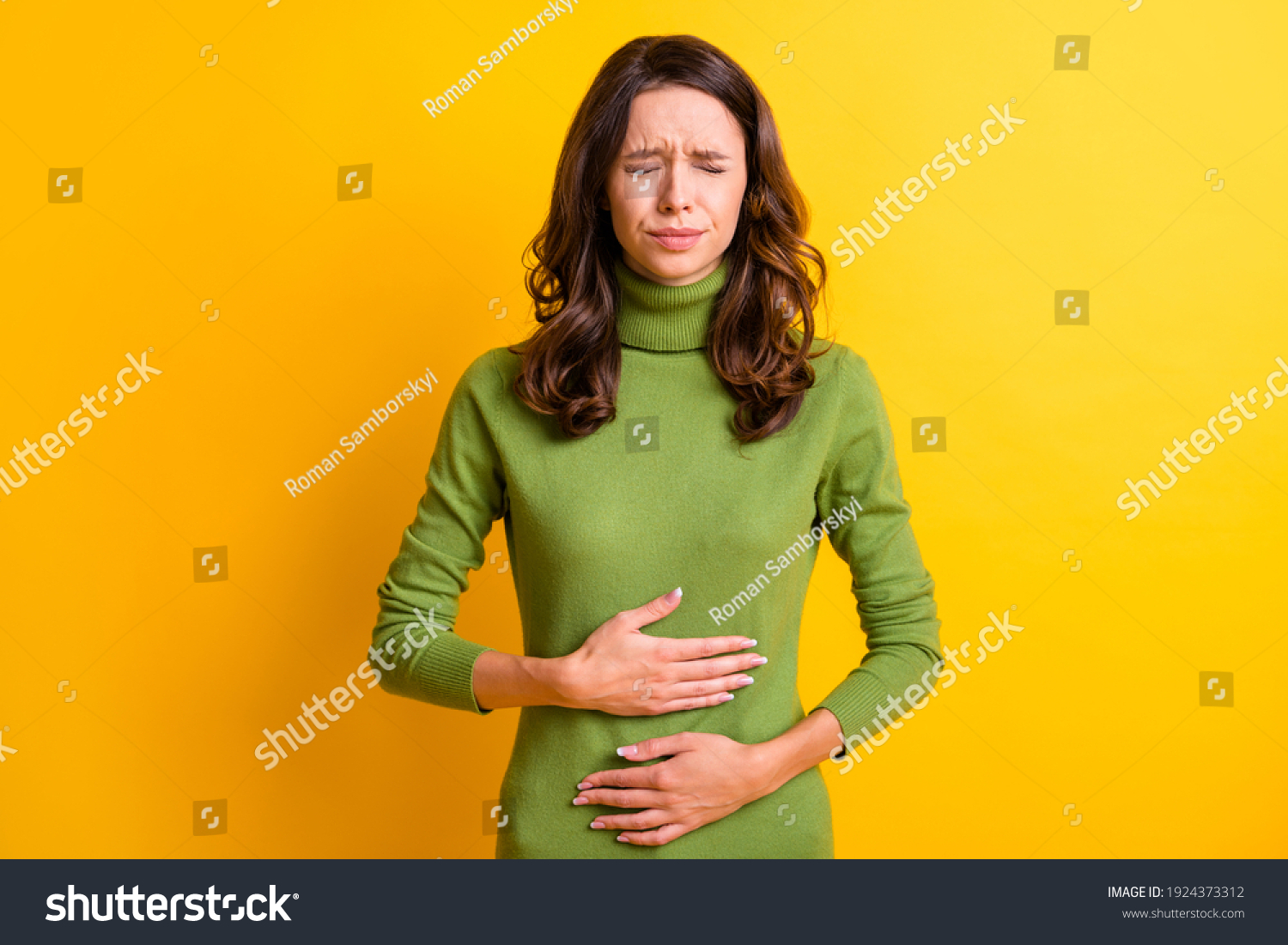 Photo of young unhappy unwell sick ill woman hold hand on stomach suffers pain pms isolated on yellow color background #1924373312