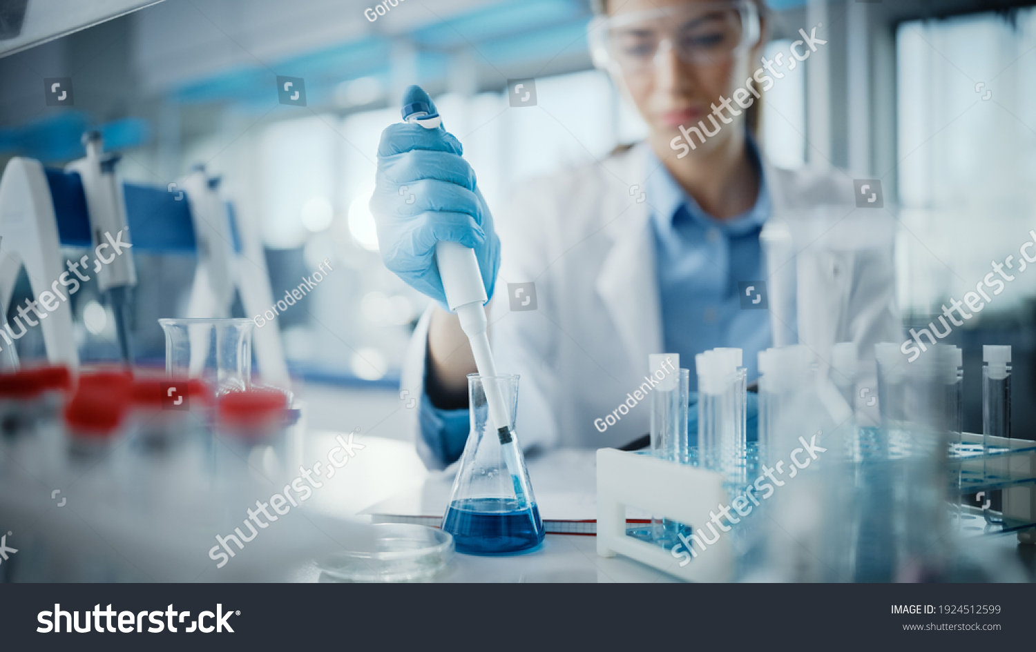 Medical Research Laboratory: Portrait of a Beautiful Female Scientist in Goggles Using Micro Pipette for Test Analysis. Advanced Scientific Lab for Medicine, Biotechnology, Microbiology Development #1924512599