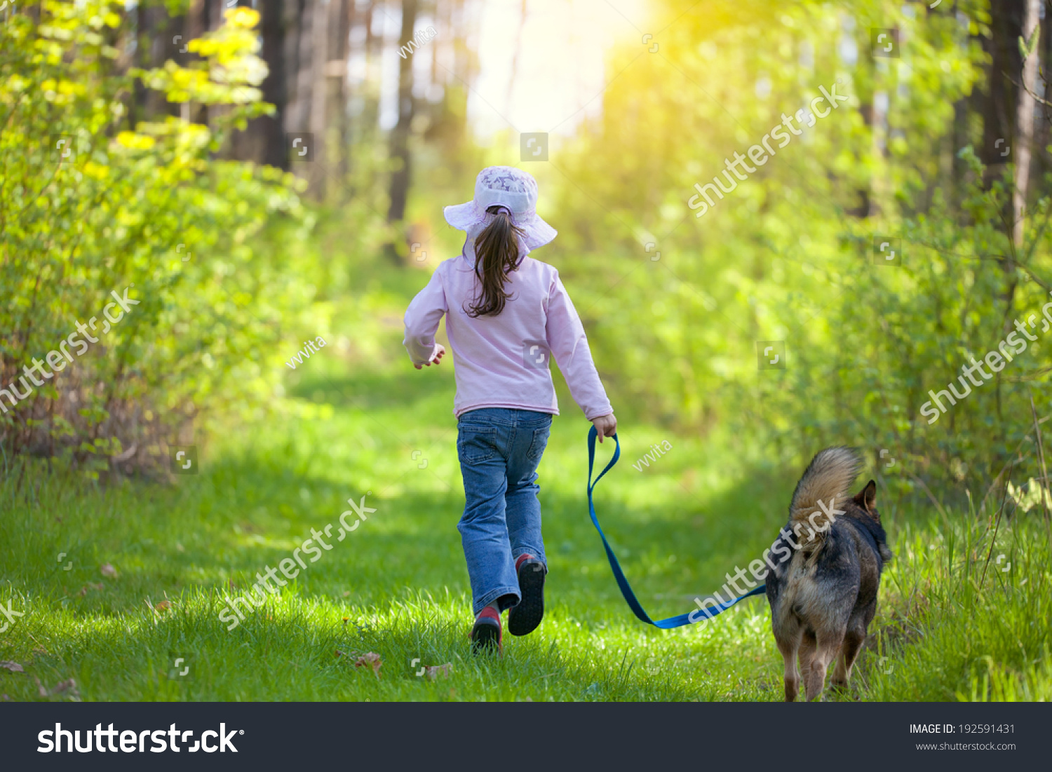 Little girl with dog running in the forest. Back to camera. #192591431