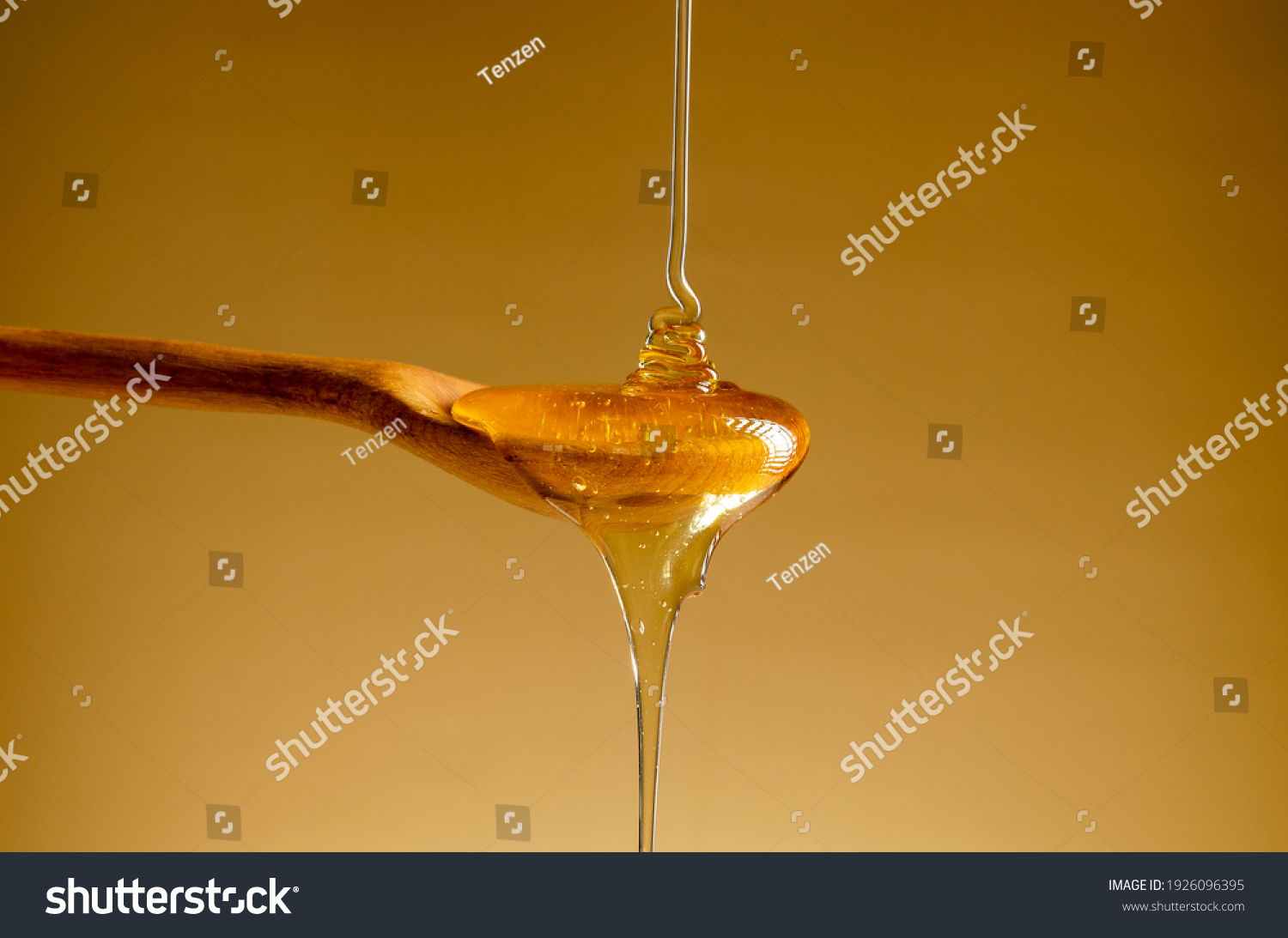 Spoon with a pouring drop of golden honey on yellow background. #1926096395