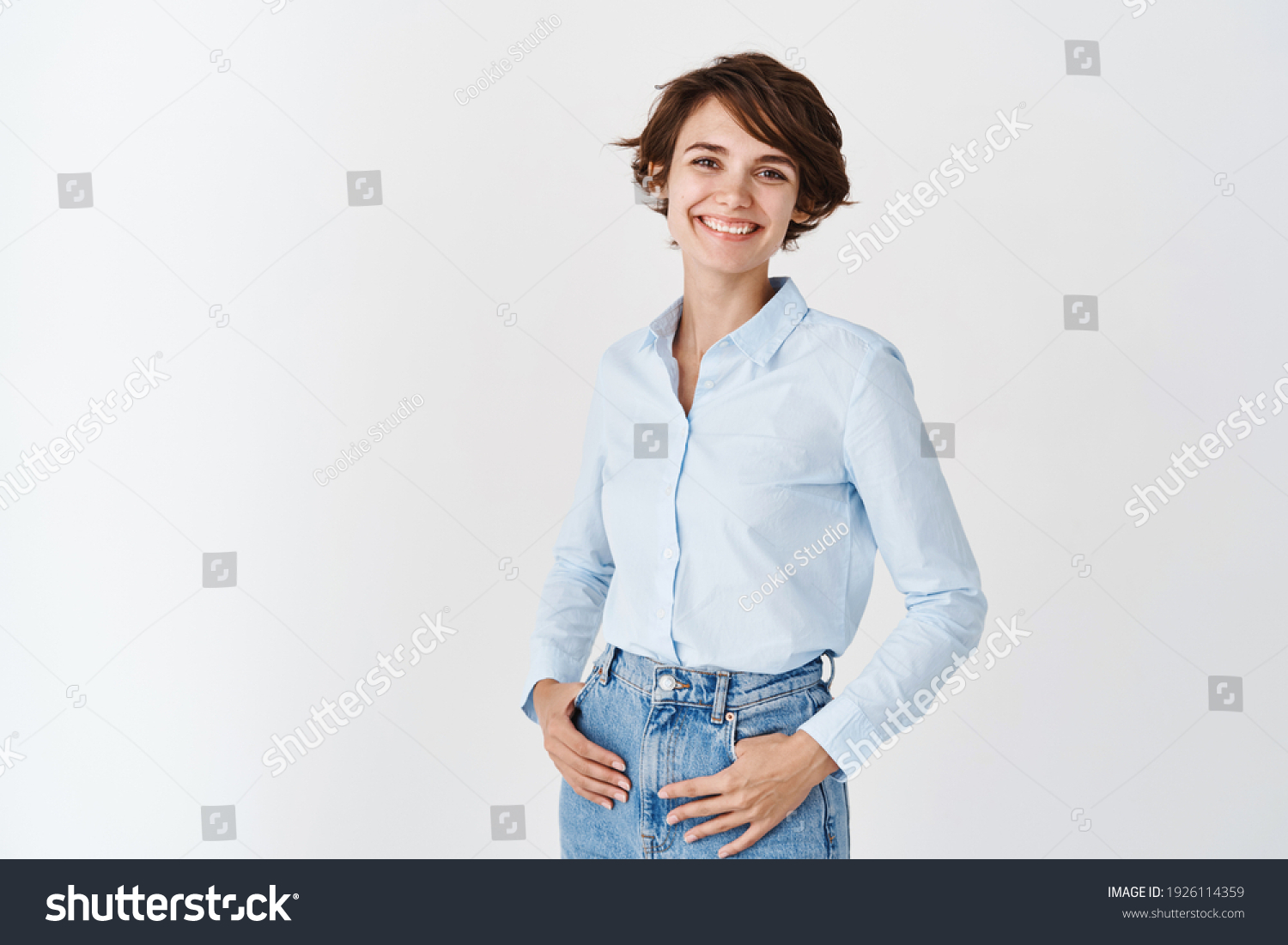 Young working woman in office clothing, smiling and looking at camera, standing on white background. Professional women concept. #1926114359