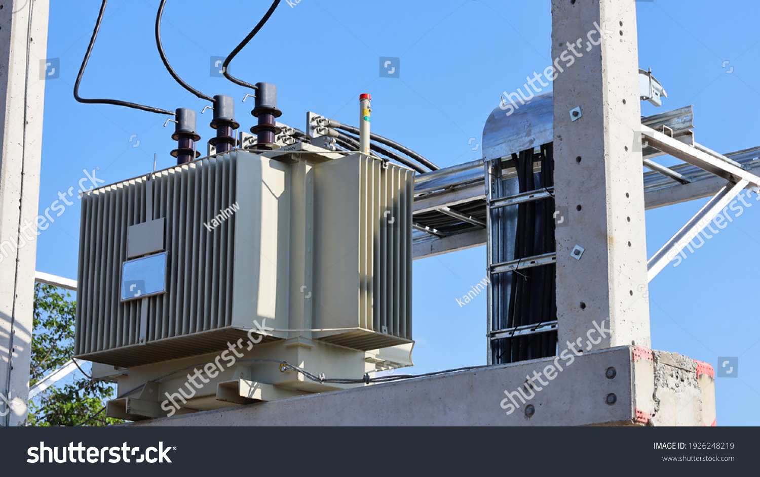 Close up the transformer on a concrete pole. Three-phase transformers and rafts on rails for industrial plants on a blue sky background. Selective focus #1926248219
