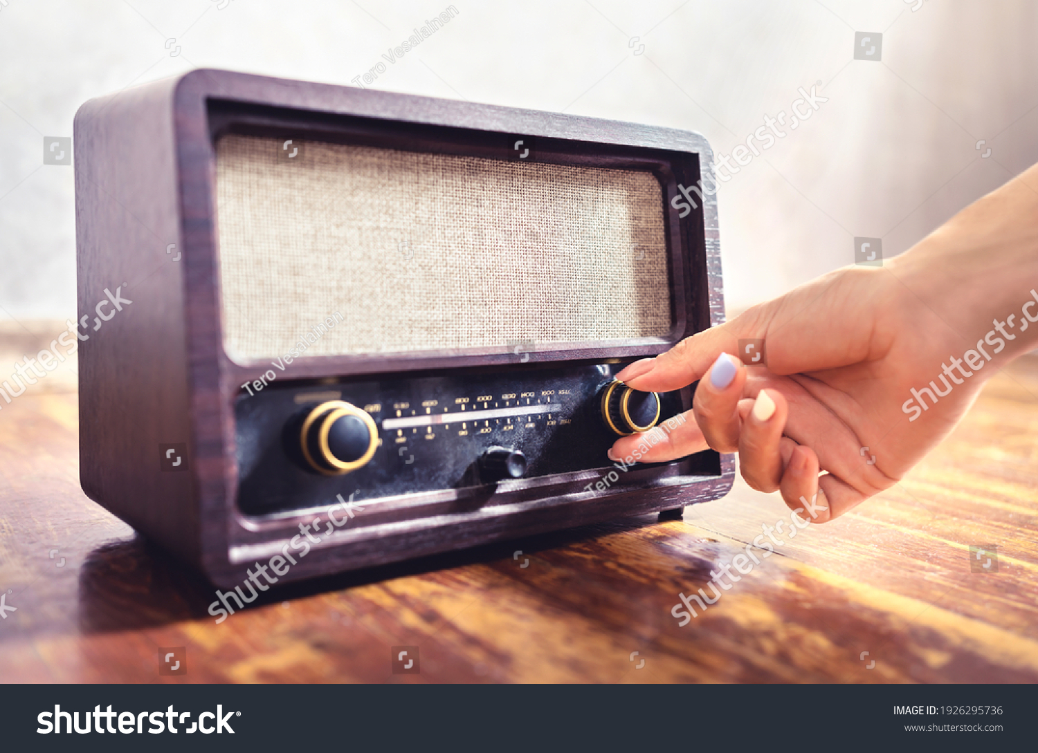 Retro radio tuning. Woman using old vintage music equipment. Adjusting volume or frequency tuner knob. Turning on or off stereo receiver or speaker. Changing channel or station with dial button. #1926295736