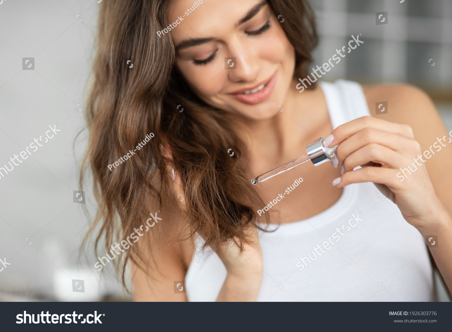 Split Ends Haircare And Repair Treatment. Woman Applying Oil To Prevent Hair Breakage Holding Dropper Standing In Modern Bathroom At Home. Remedy And Care For Beauty Of Damaged Hair. Selective Focus #1926303776