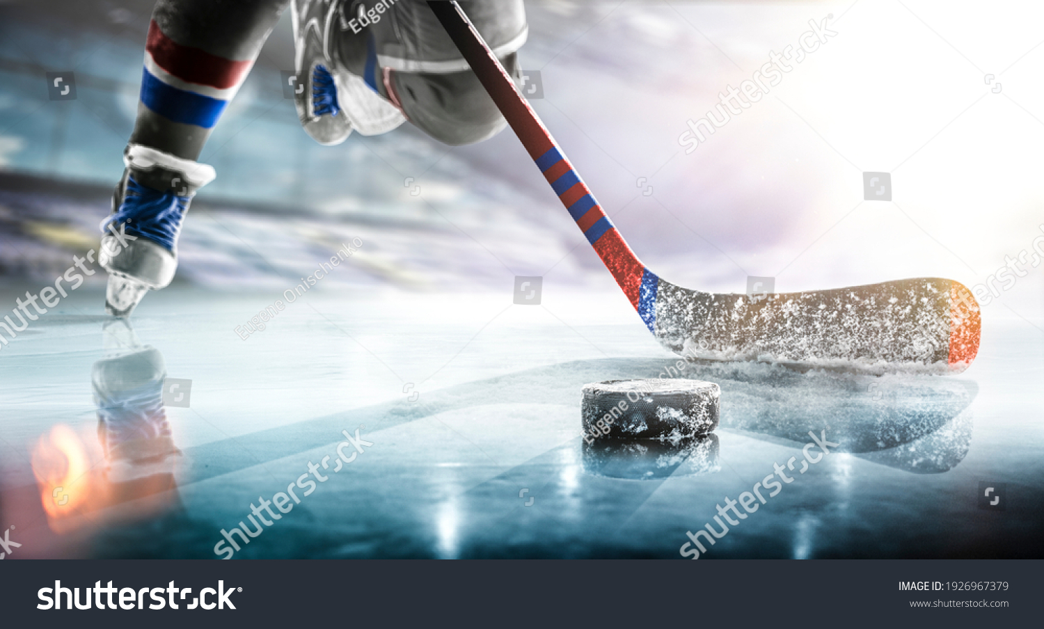 Close up of ice hockey stick on ice rink in position to hit hockey puck. #1926967379