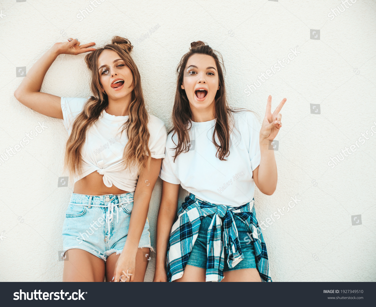 Portrait of two young beautiful smiling hipster women in trendy summer white t-shirt clothes.Sexy carefree women posing on street background. Positive models having fun, hugging and going crazy #1927349510