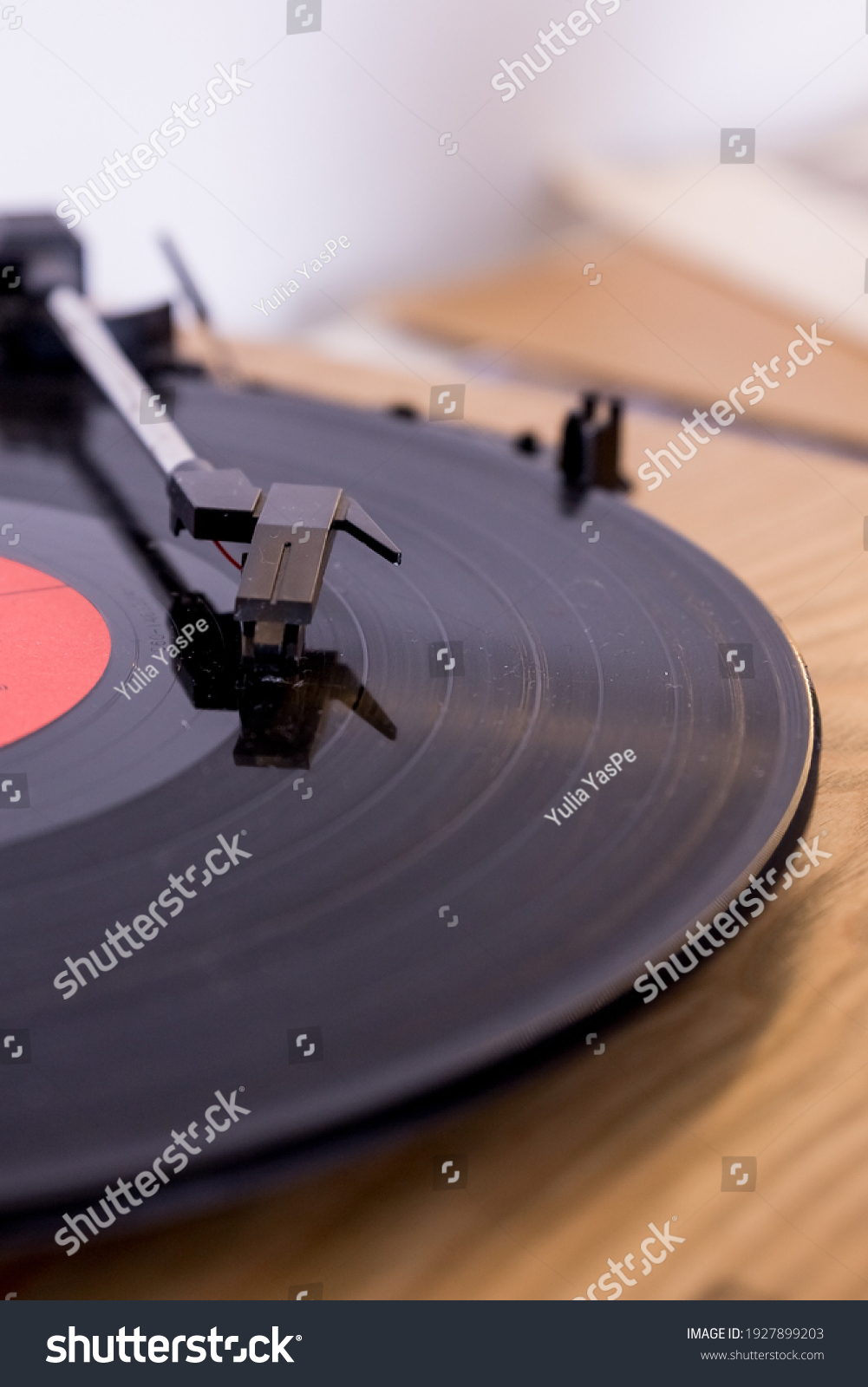 retro player with a vinyl disk on blurred background.Old gramophone turntable with disc.playing vinyl close up with needle on the record #1927899203