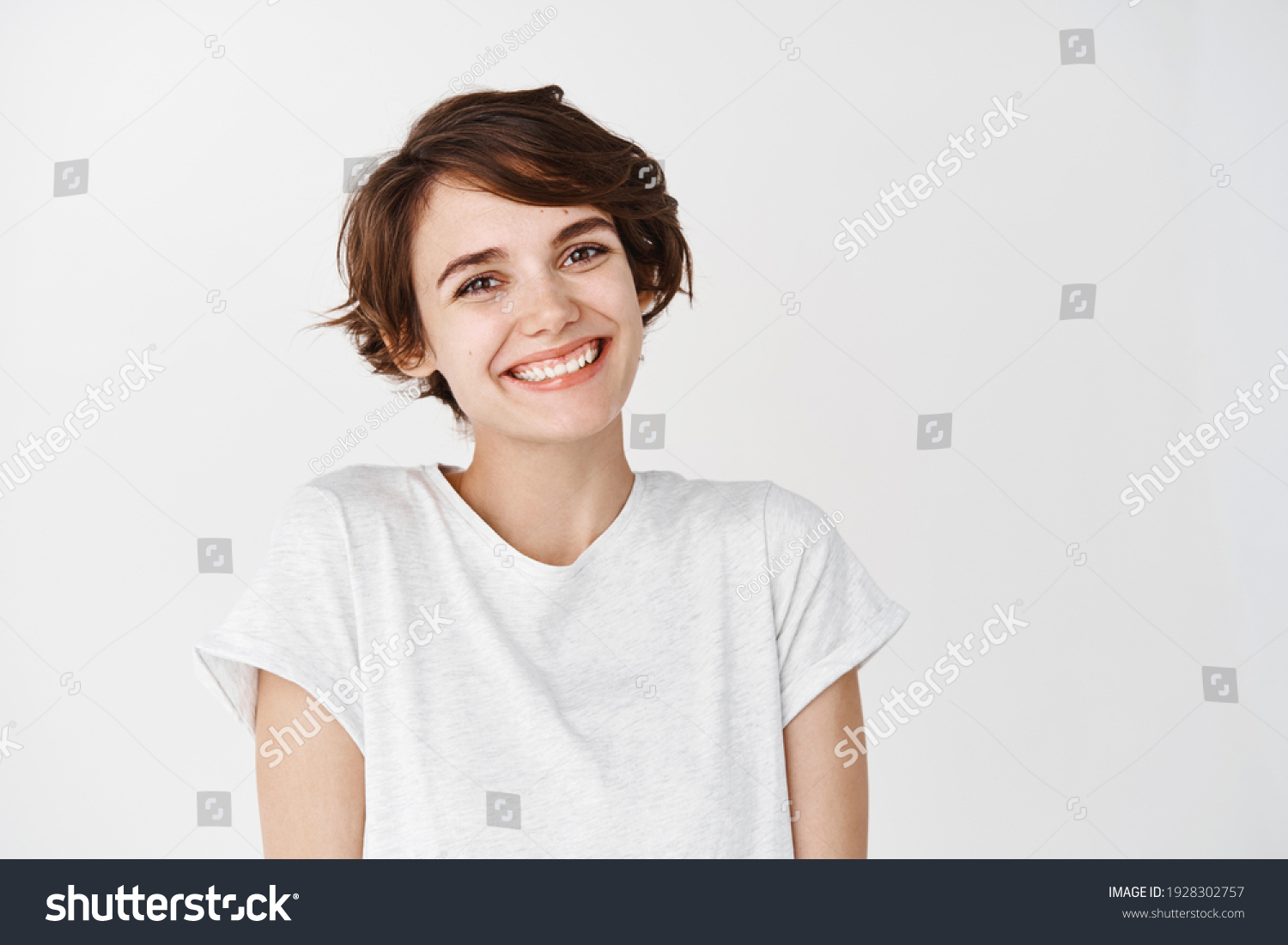 Portrait of authentic happy woman without makeup, smiling at camera, standing cute against white background. #1928302757
