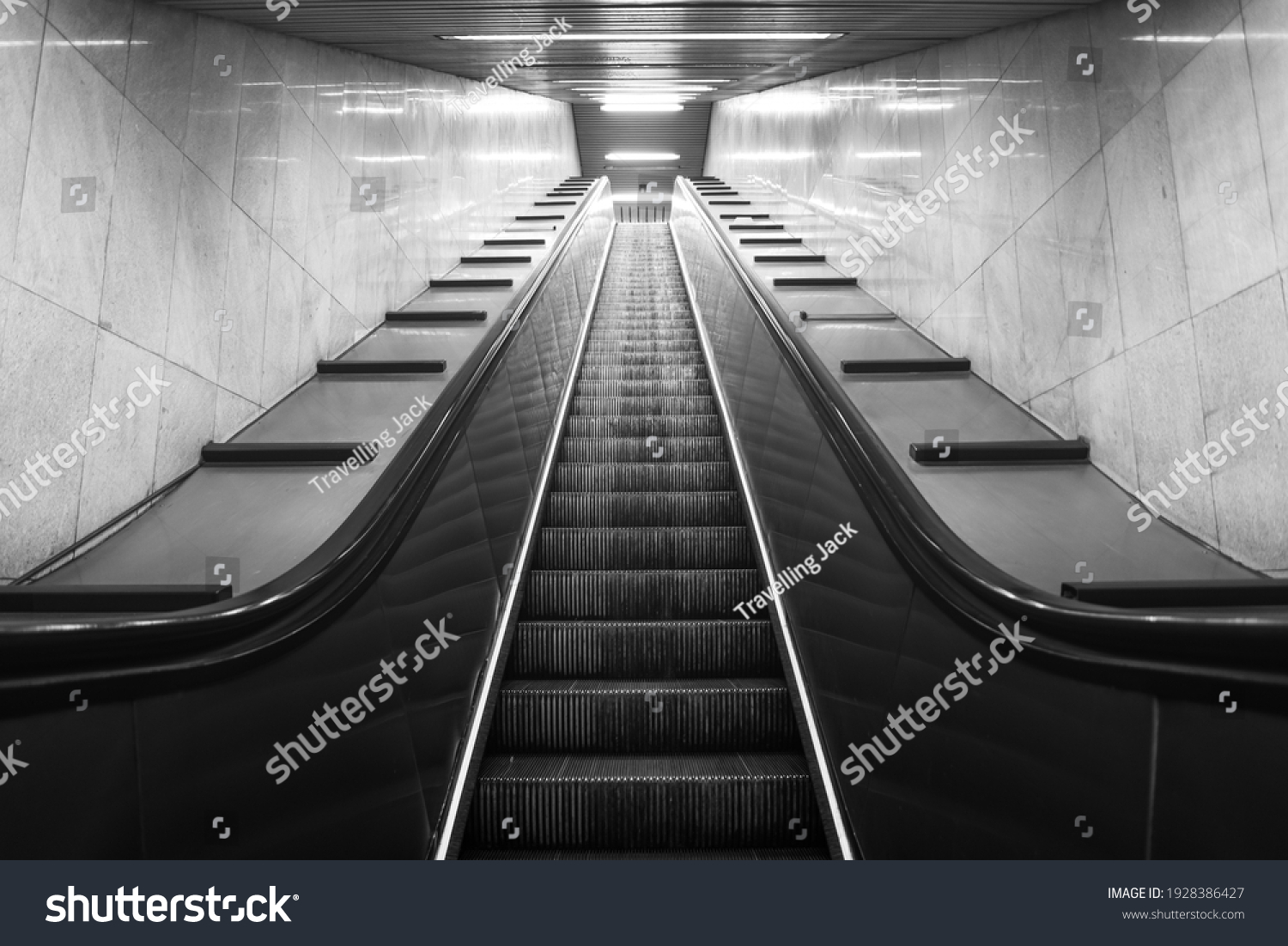 Perspective of mobile staircase in Milan's underground station. Light at the end of the tunnel. Monochromatic. #1928386427