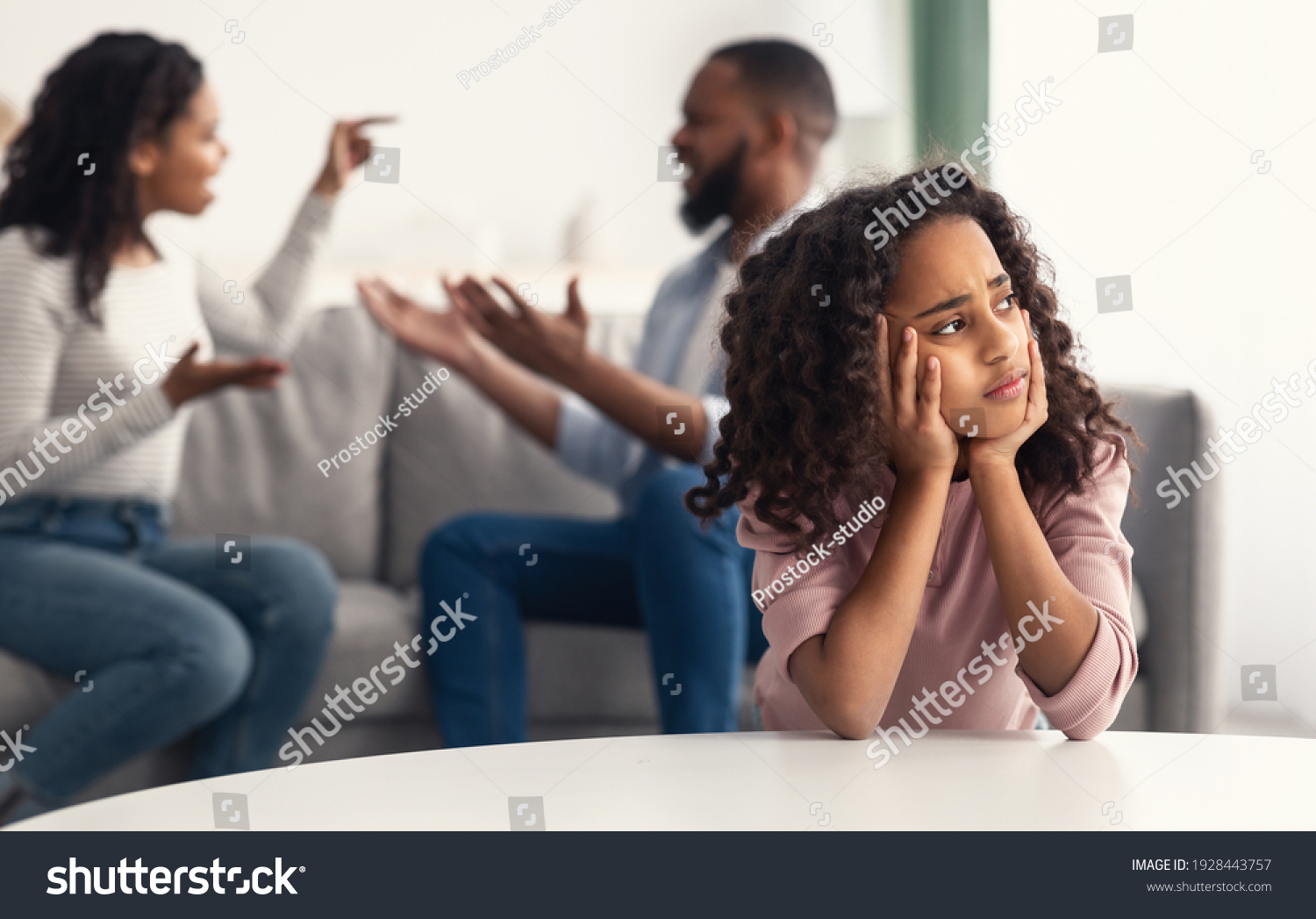 Divorce And Domestic Violence. Portrait of upset African American daughter looking through the window while her angry parents fighting in the background, depressed child feeling lonely #1928443757