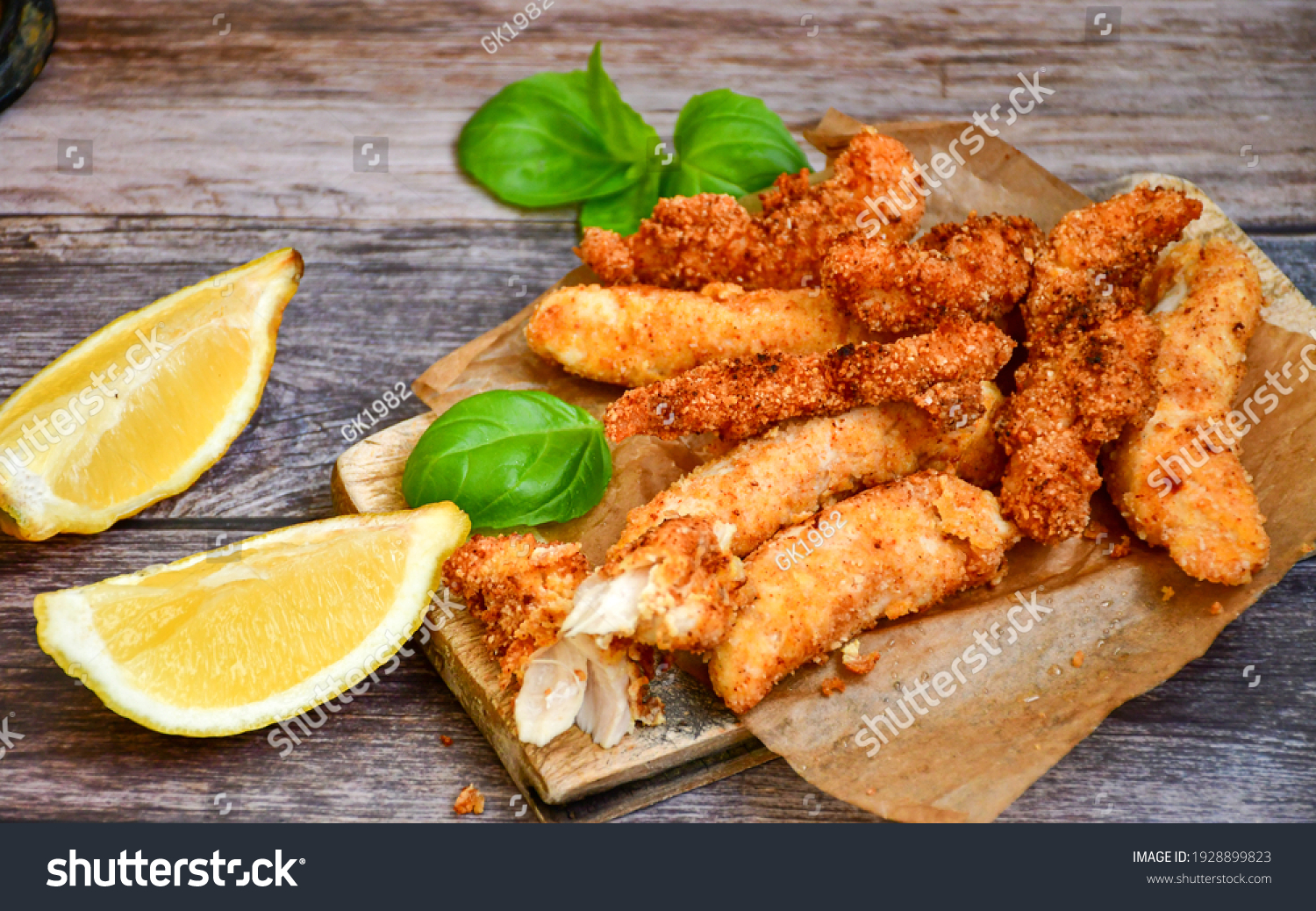 
 Crispy  deep fried home made    chicken strips Breaded  with  almond flour chicken  breast fillets  with chilly peppers and fresh   basil on wooden rustic background. Ketogenic diet food #1928899823