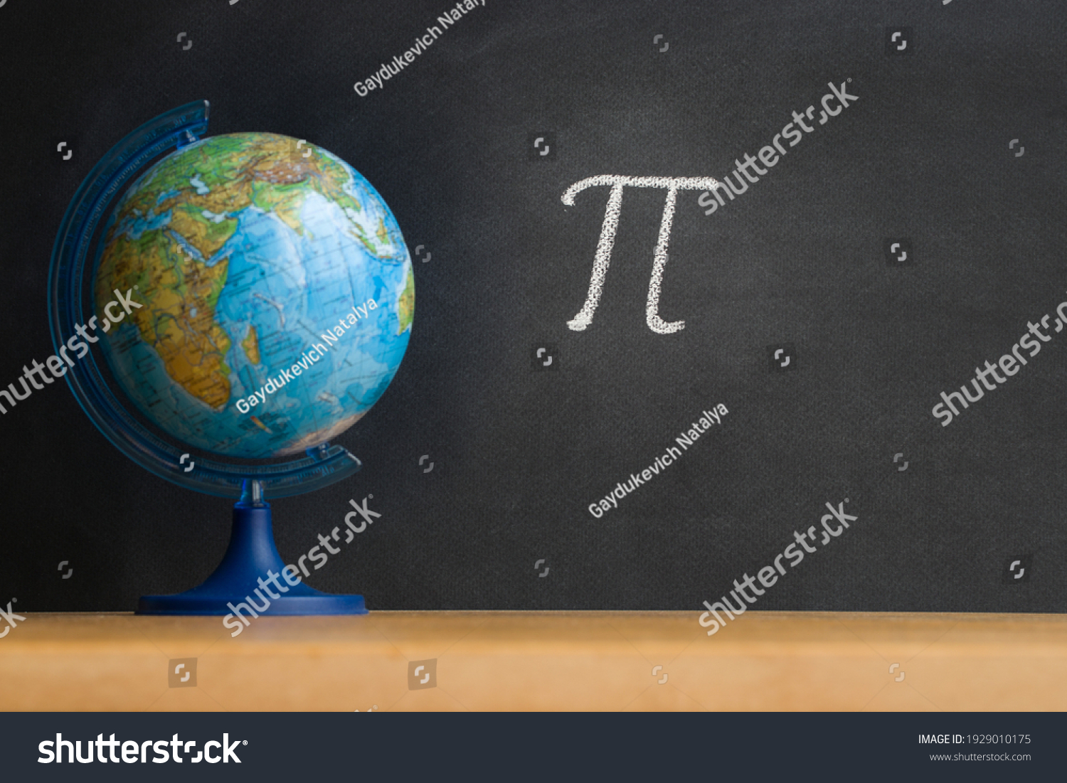 The Greek letter Pi, the ratio of the circumference to its diameter, is drawn in chalk on a black chalkboard in honor of the international number Pi for March 14 #1929010175