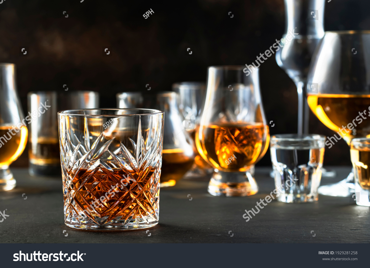 Hard strong alcoholic drinks and distillates in glasses in assortment: vodka, cognac, tequila, scotch, brandy and whiskey, grappa, liqueur, vermouth, tincture, rum. Brown background #1929281258