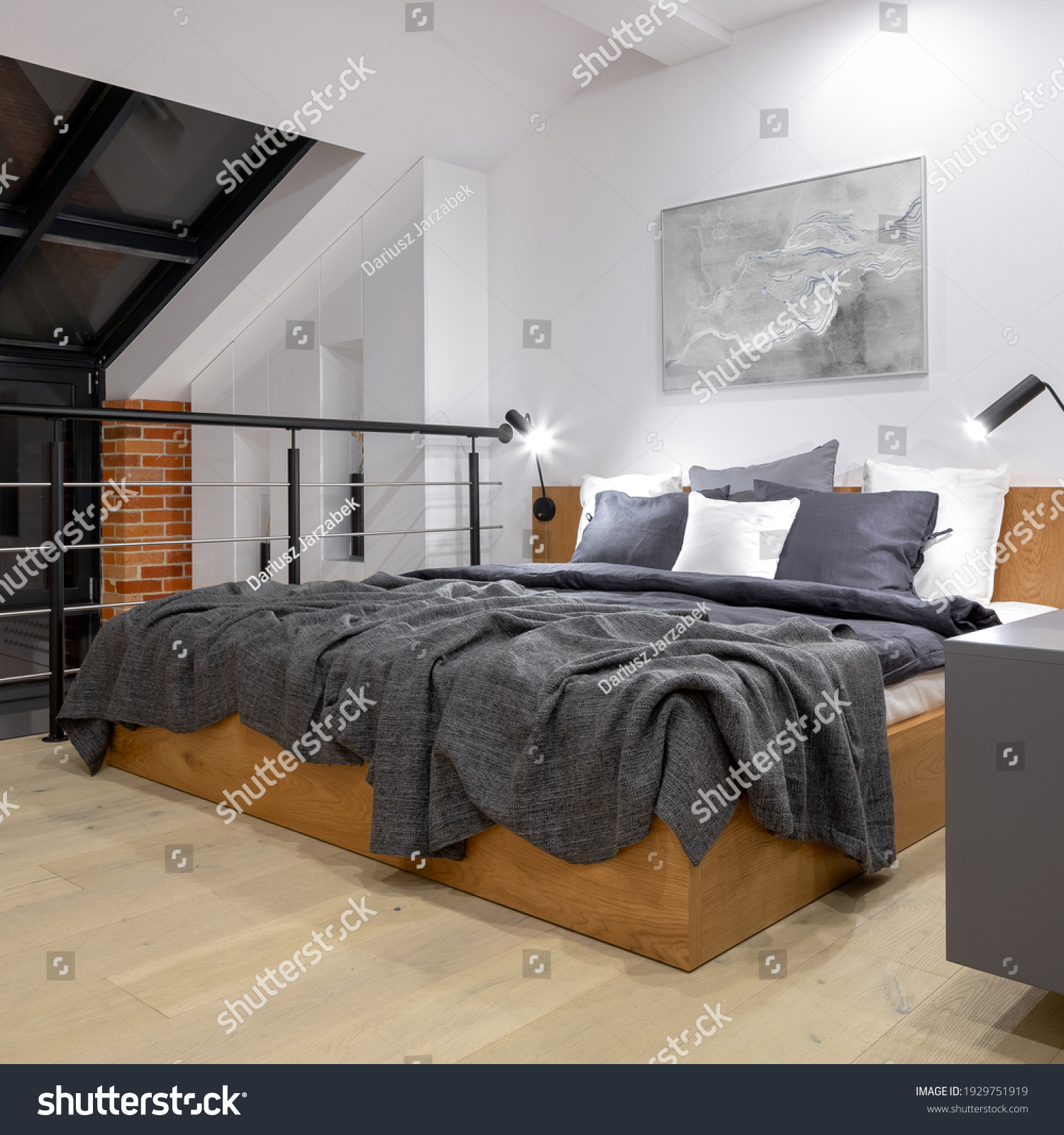 Comfortable bed on modern attic bedroom on mezzanine floor in loft style apartment with big window and white walls #1929751919