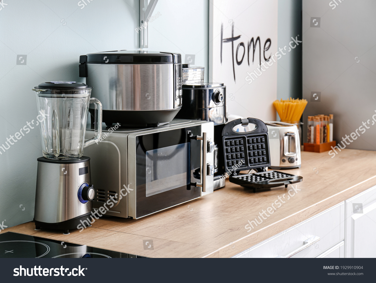 Different household appliances on table in kitchen #1929910904