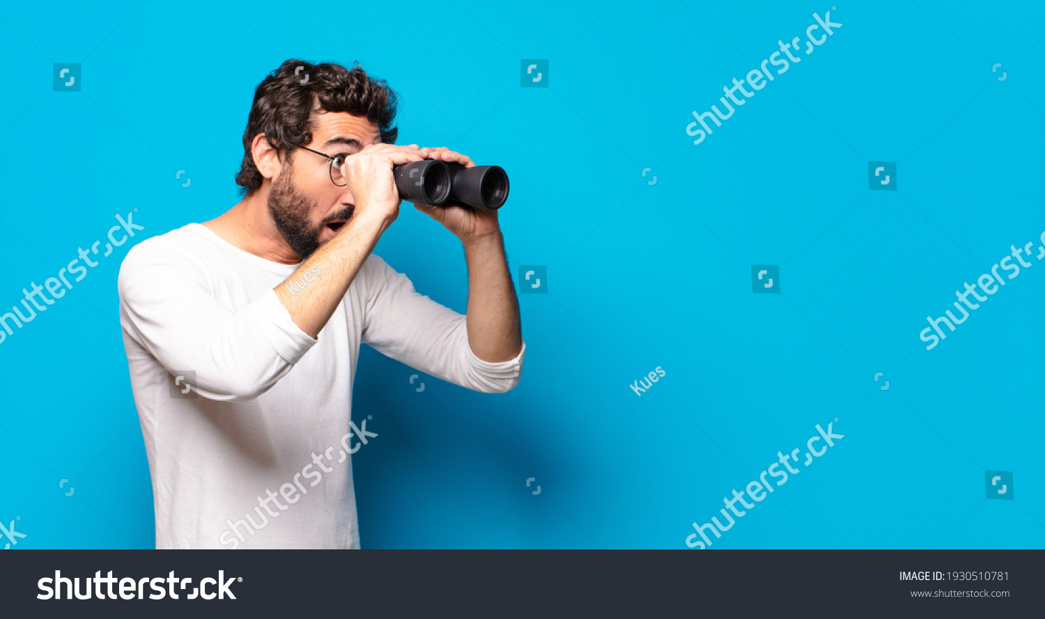 young crazy bearded man with binoculars #1930510781