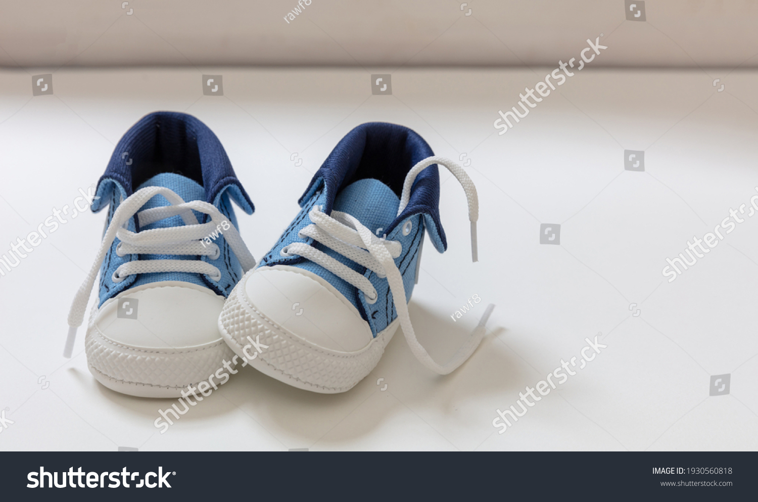 Baby boy sport shoes on white color background. Kid small size blue sneakers, canvas booties closeup view. Space, card invitation template #1930560818