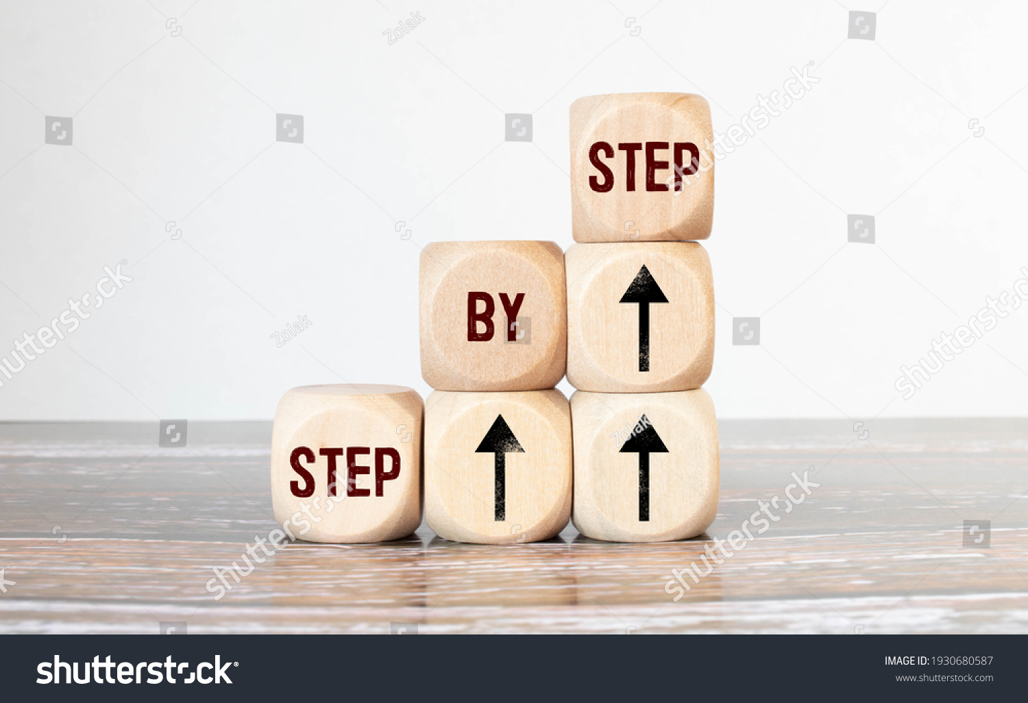 The word step by step on wooden cubes. Achievement or progress in business career. #1930680587