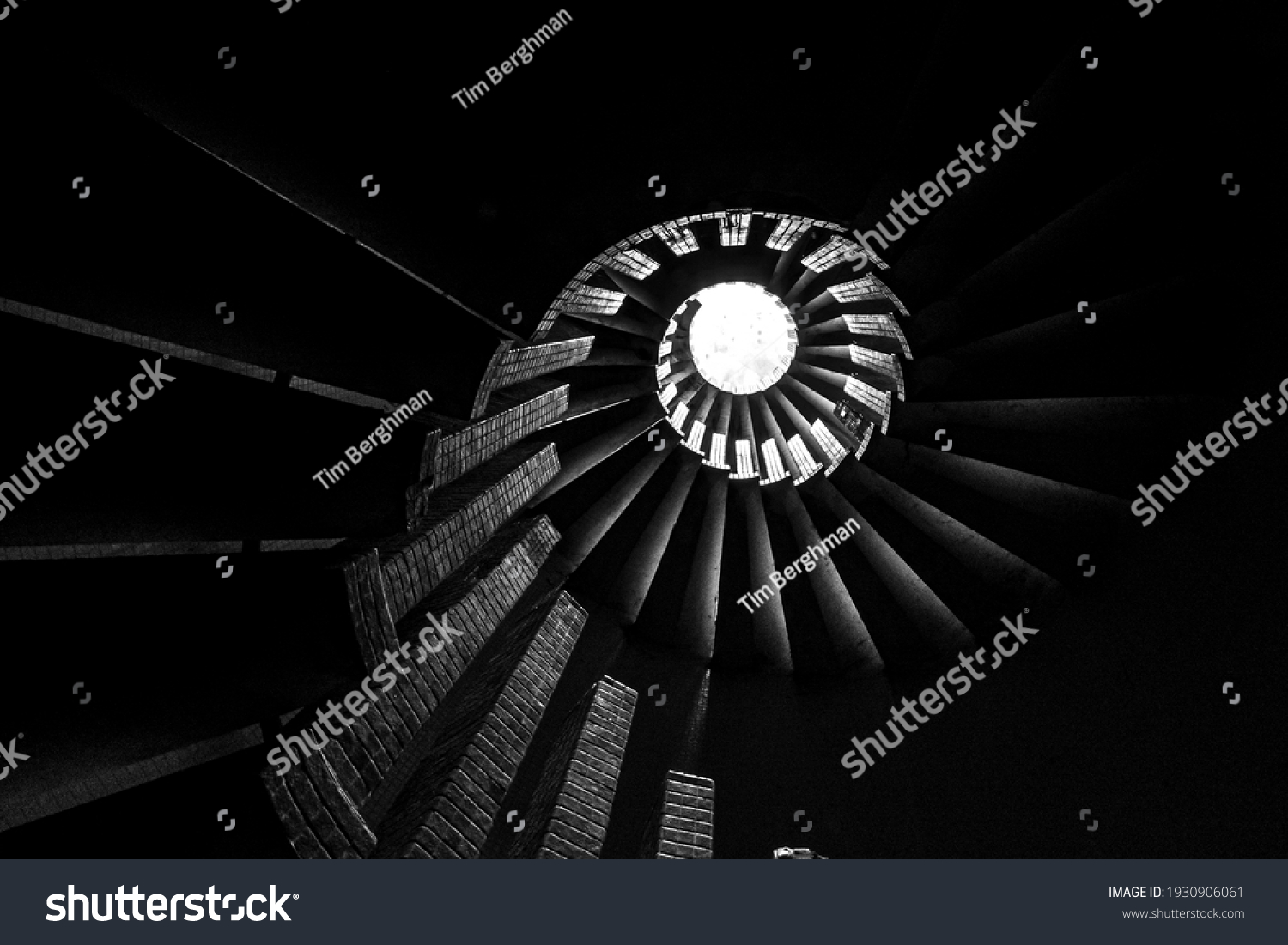 Spiral staircase with steps, upward view of a skylight, in monochrome #1930906061