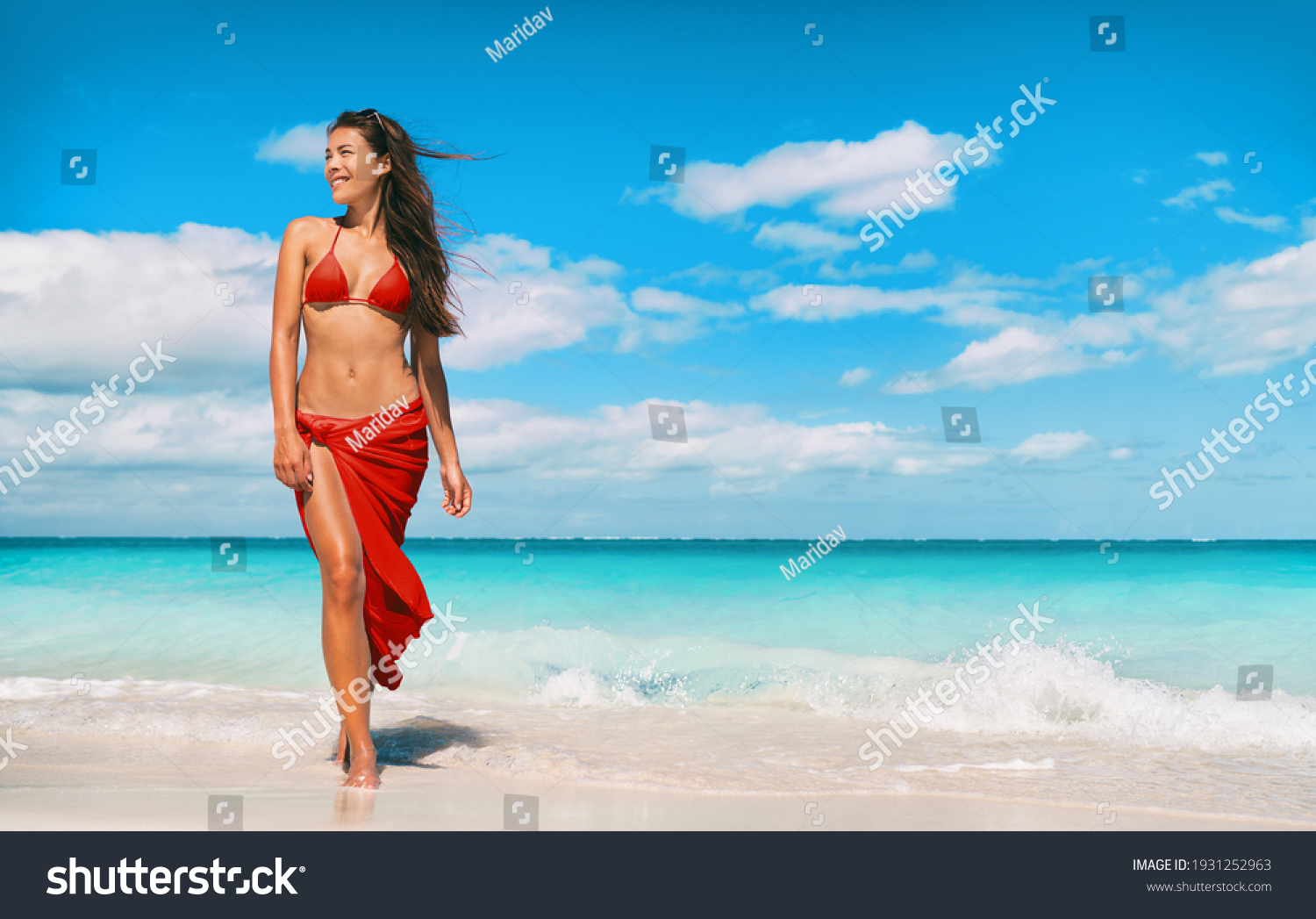 Beach bikini model in red swimsuit and skirt for wellness spa luxury. Hair removal laser treatment for legs and body summer ready vacation Asian woman walking relaxing at Caribbean travel holiday. #1931252963