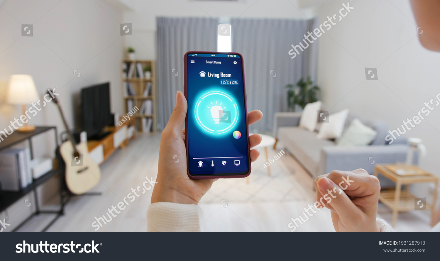 Asian young woman is using smart home app and touch screen to turn on the light by mobile phone #1931287913