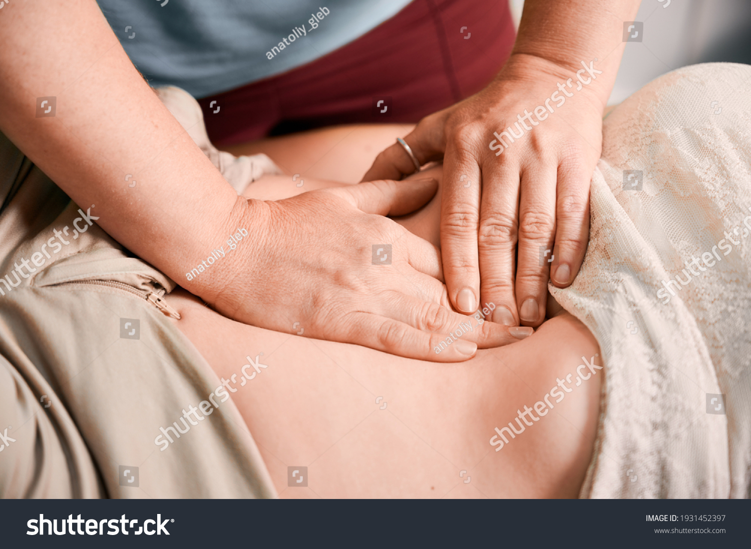 Close up of physician hands massaging woman abdomen during medical examination. Doctor examining patient stomach in clinic. Concept of healthcare, therapeutic massage and medical examination. #1931452397