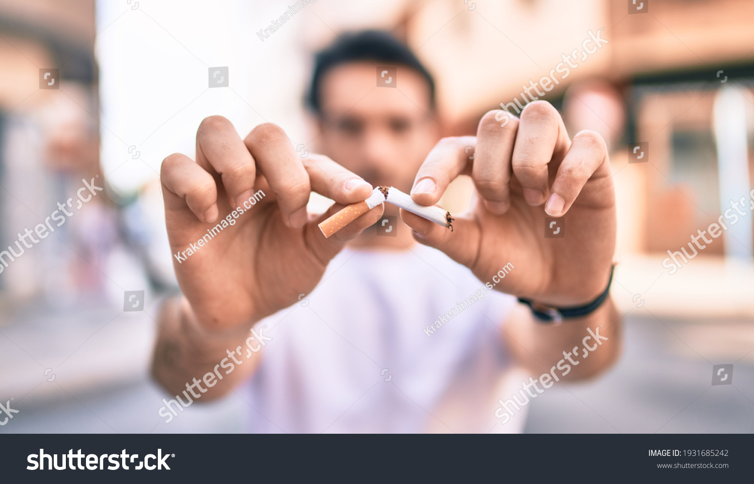 Young hispanic man breaking cigarette with hands walking at the city. #1931685242