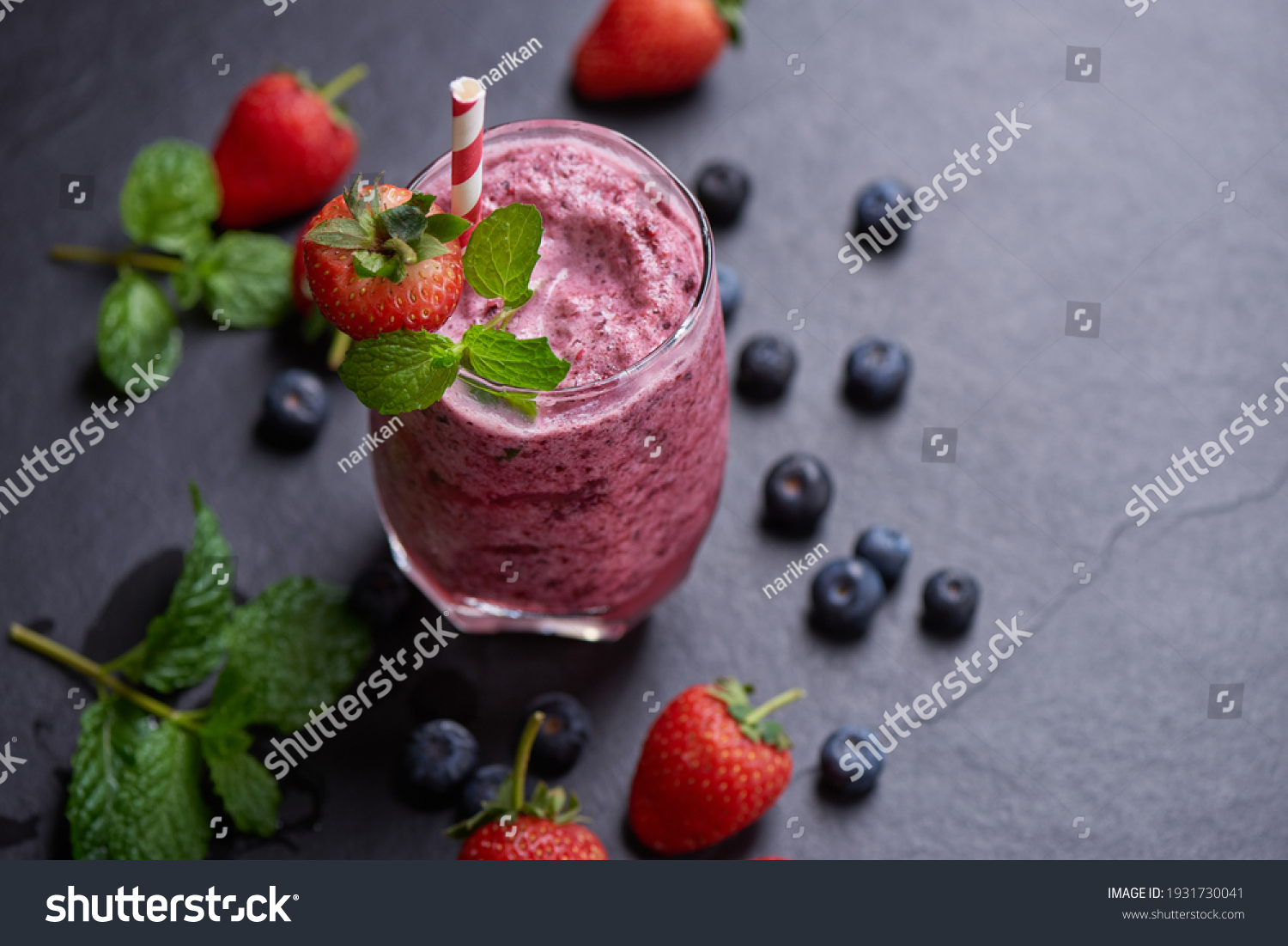 Delicious strawberry, mulberry and blueberry smoothie garnished with fresh berries and mint in glass. soft focus. beautiful appetizer pink raspberries, well being and weight loss concept. #1931730041