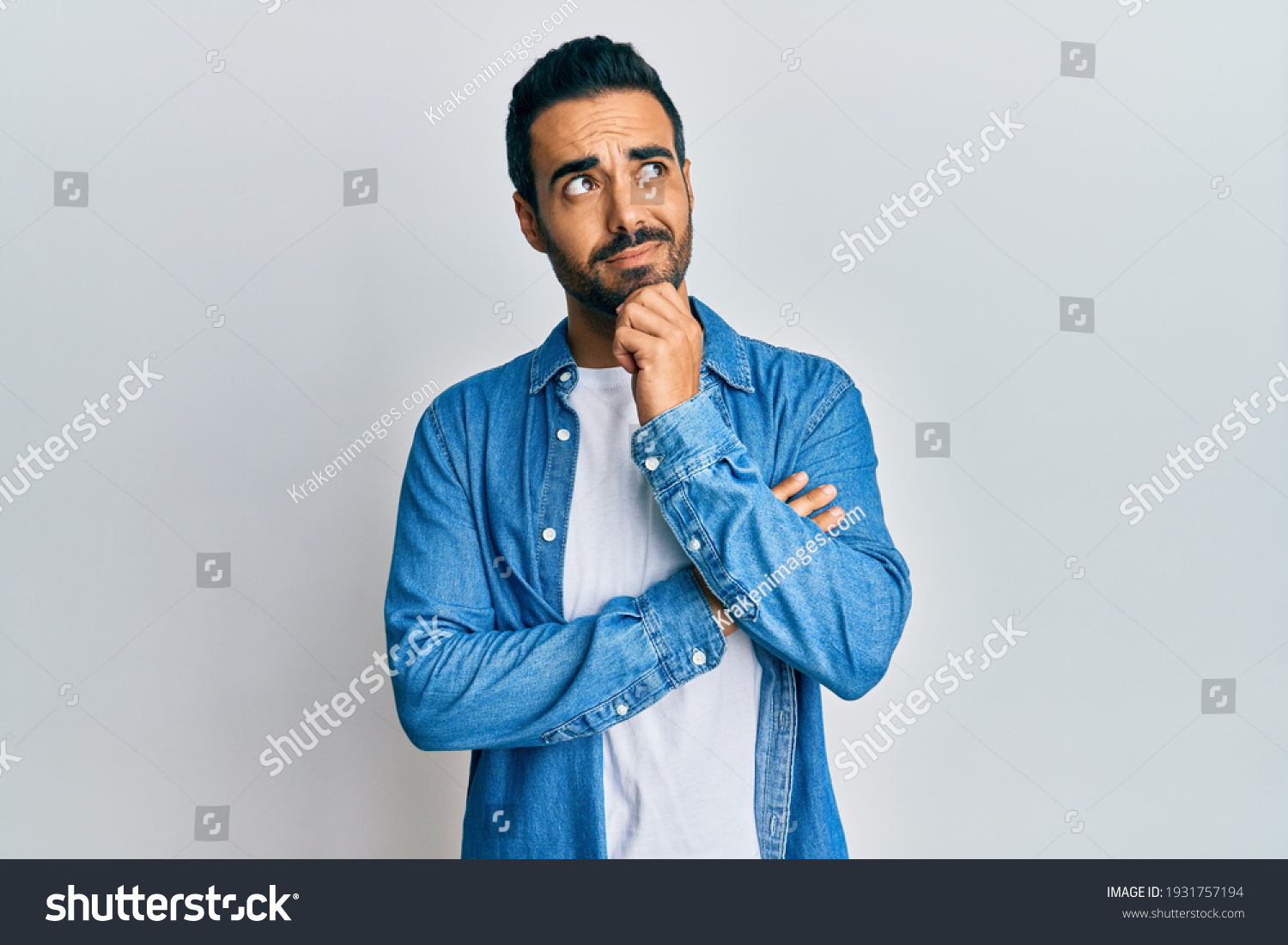 Young hispanic man wearing casual clothes thinking concentrated about doubt with finger on chin and looking up wondering  #1931757194