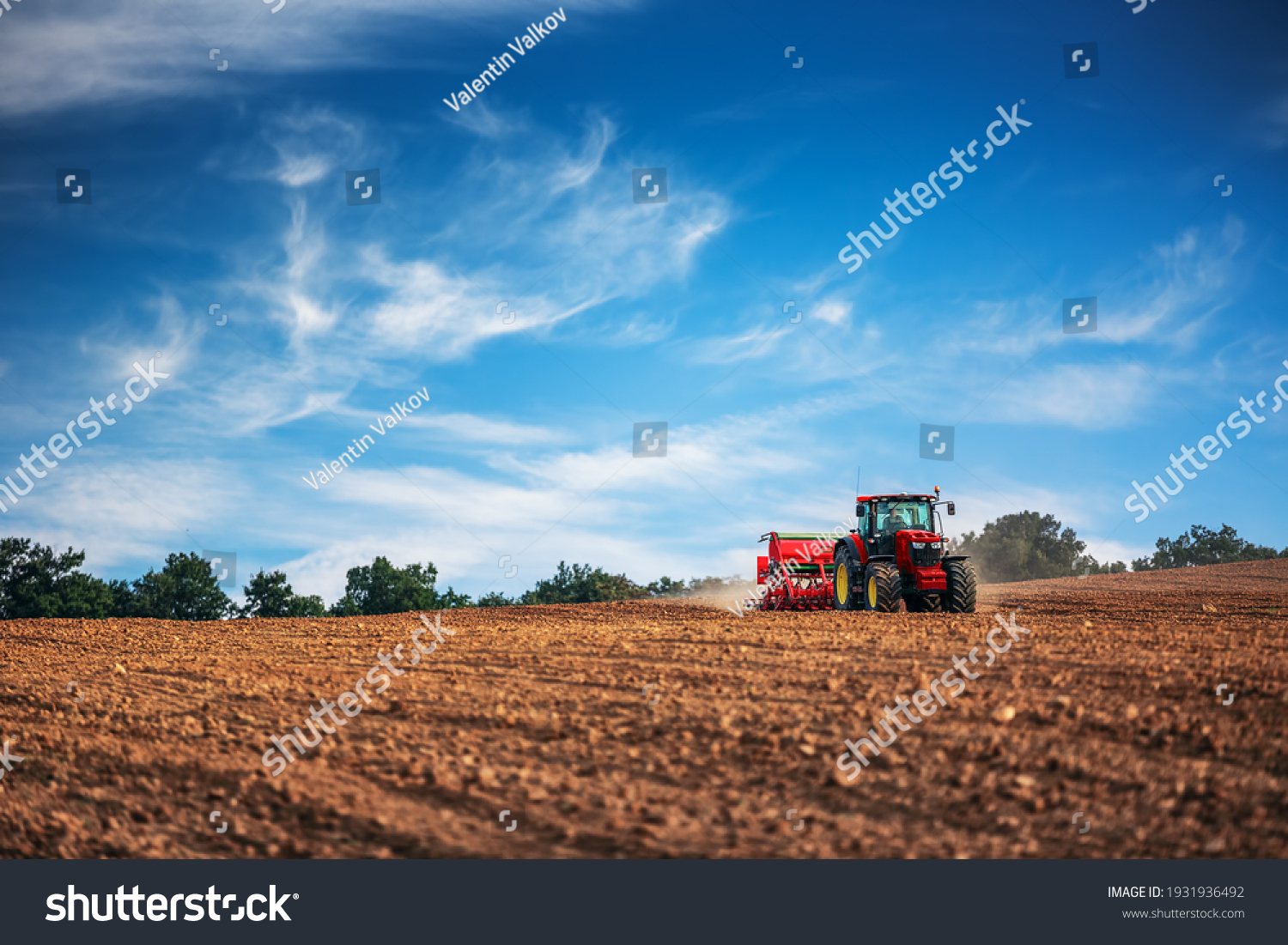 Farmer in tractor preparing farmland with seedbed for the next year #1931936492