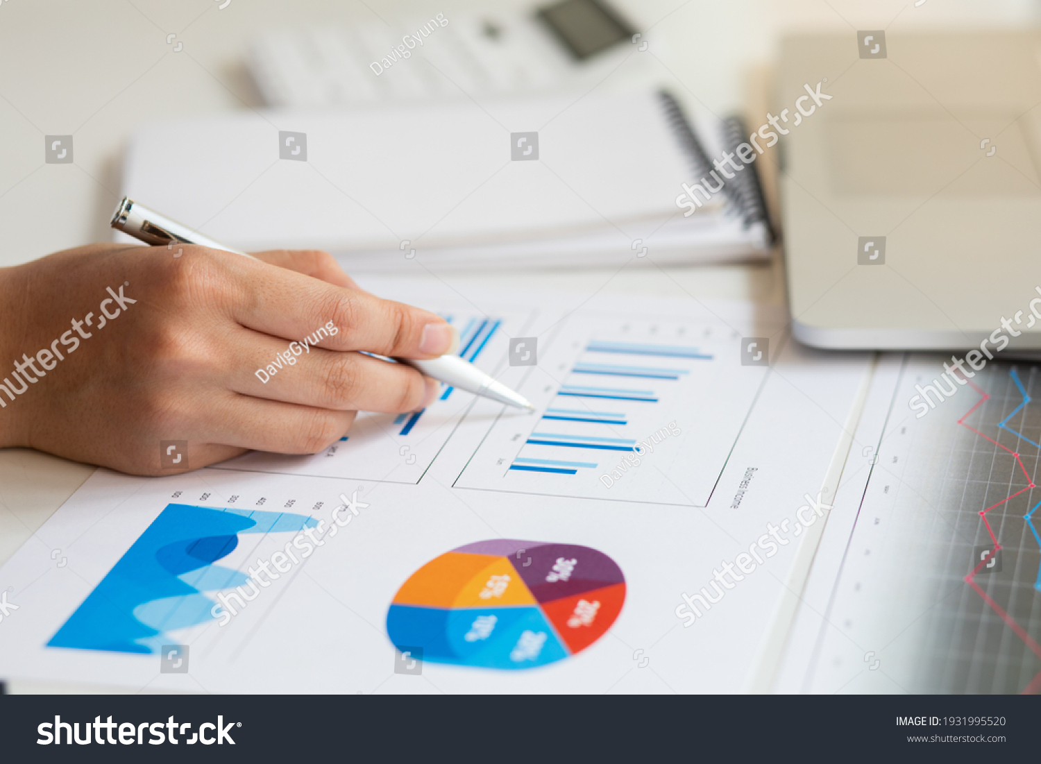 Close up of accountant working and analyzing financial reports project accounting with chart graph and calculator in modern office : finance and business concept. #1931995520