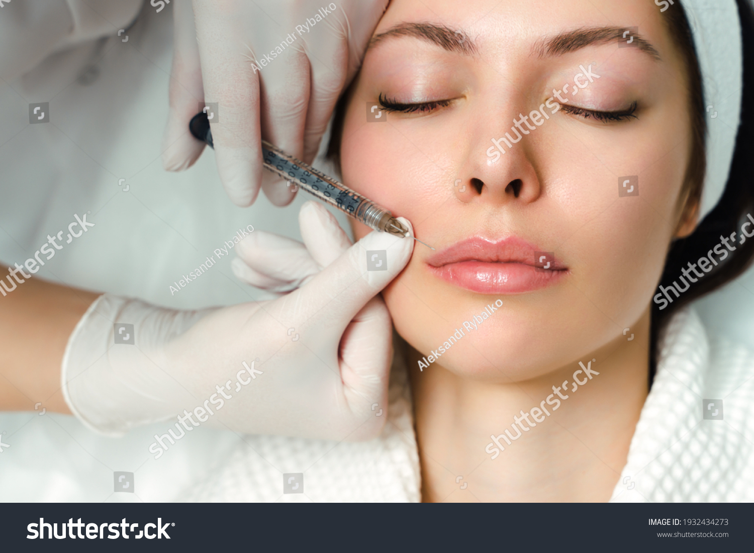 Lip augmentation and correction procedure in a cosmetology salon. The specialist makes an injection in the patient's lips #1932434273