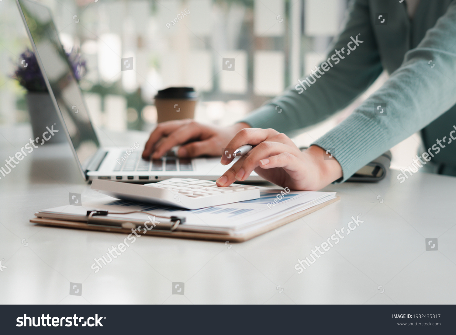businessman working on desk office with using a calculator to calculate the numbers, finance accounting concept #1932435317