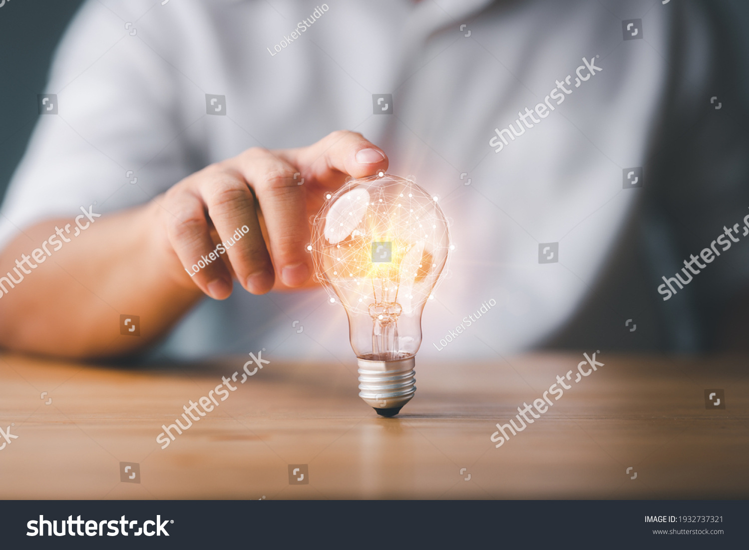 Businessman touching a bright light bulb. Concept of Ideas for presenting new ideas Great inspiration and innovation new beginning. #1932737321
