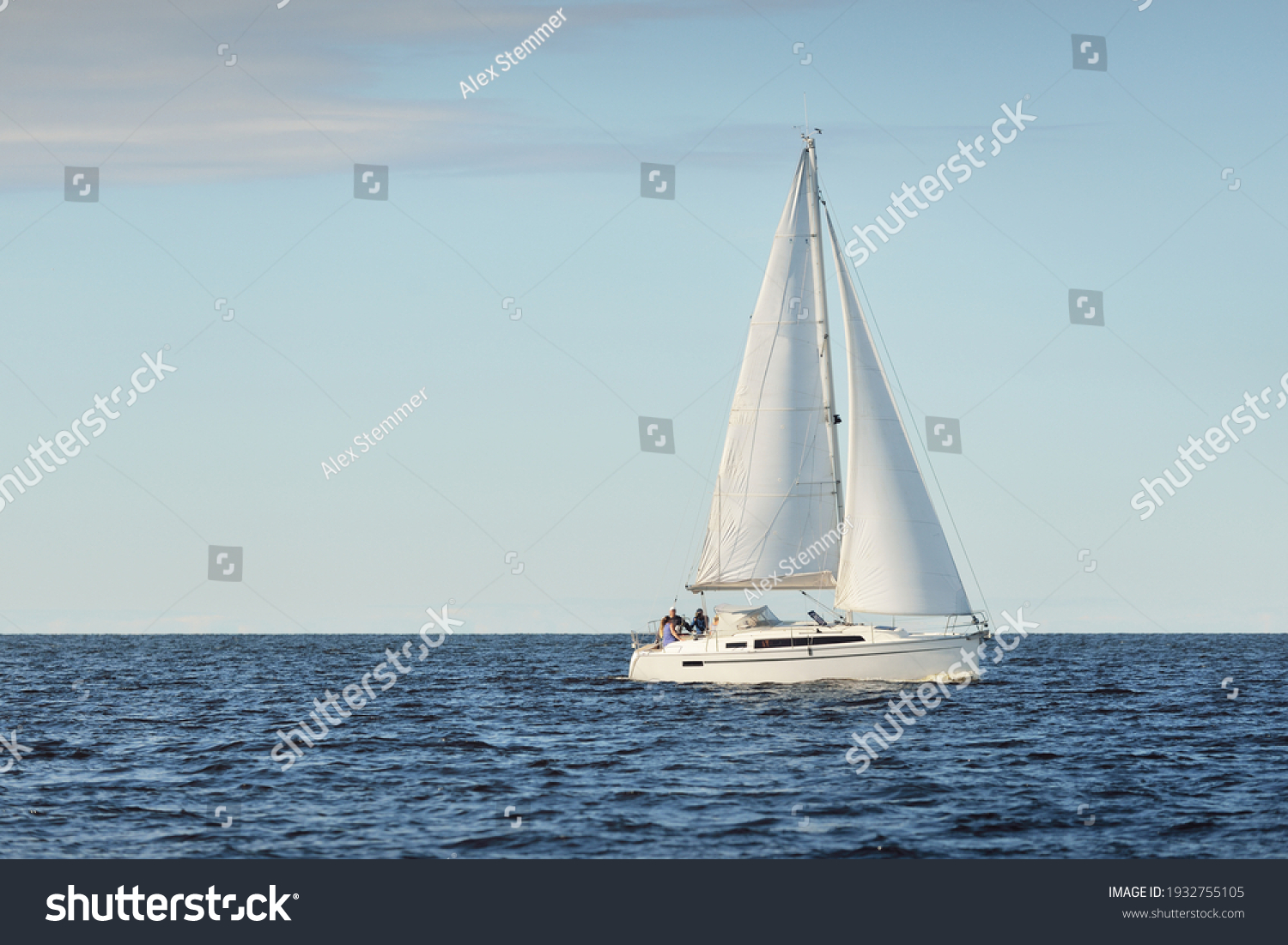White sloop rigged yacht sailing in the Baltic sea at sunset. Clear sky after the storm, soft sunlight. Transportation, travel, cruise, sport, recreation, leisure activity, racing, regatta #1932755105