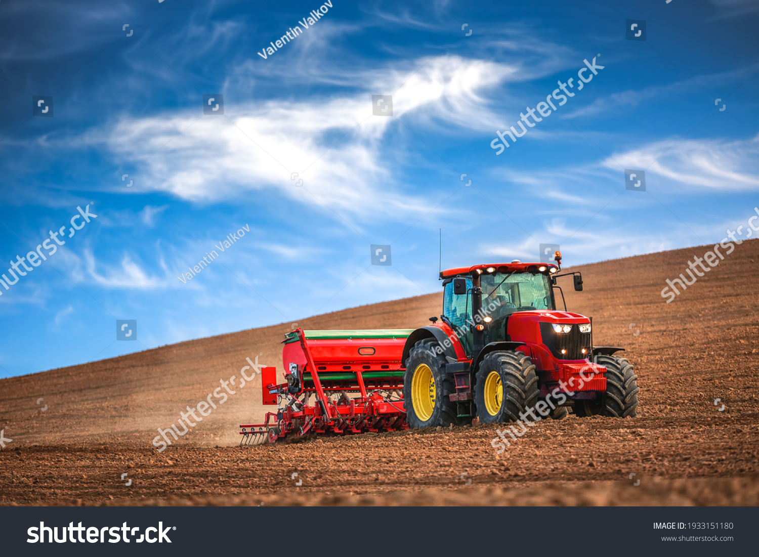 Farmer in tractor preparing farmland with seedbed for the next year #1933151180
