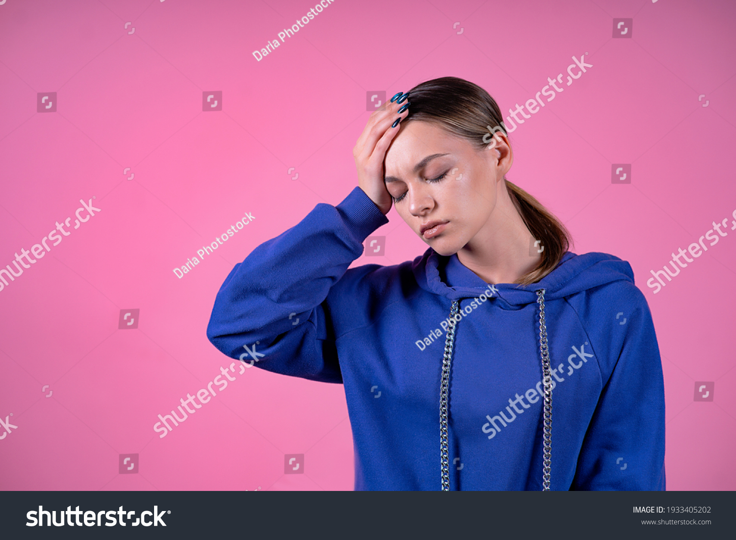 Tired, sick, emaciated girl, young sleepy woman suffering from headache, migraine, lack of sleep, holding her forehead with her hand. Insomnia, fever, health care concept. On pink isolated background #1933405202