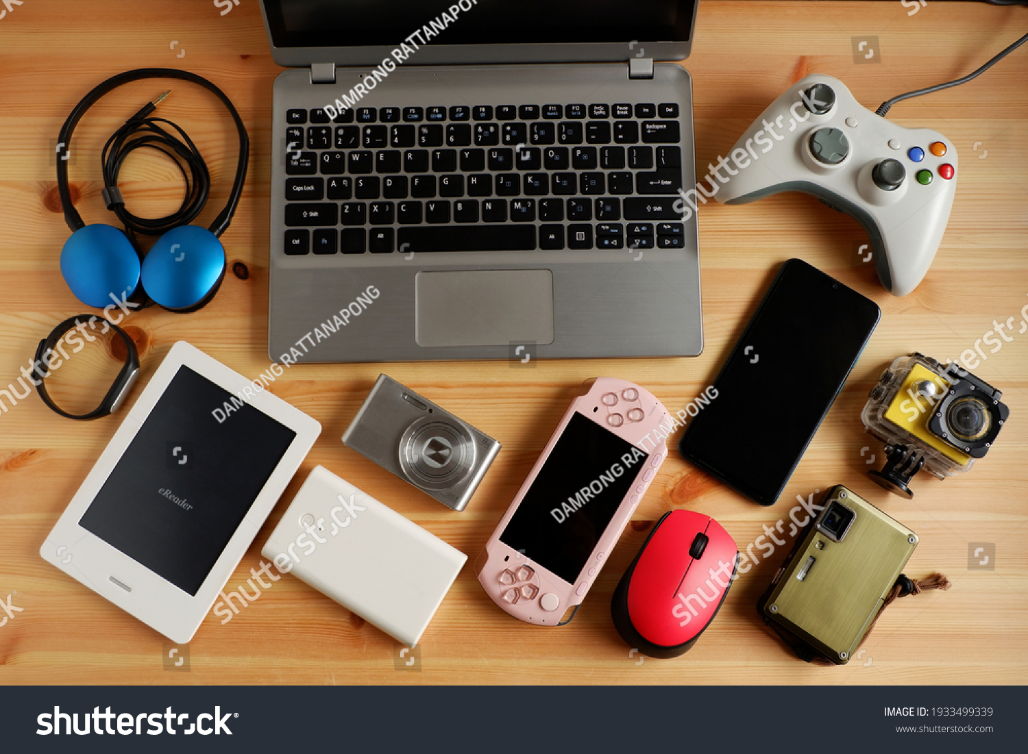laptop computer with Smartphone and portable game consoles and ebook reader and many electronic gadgets on wooden background.Top view. #1933499339